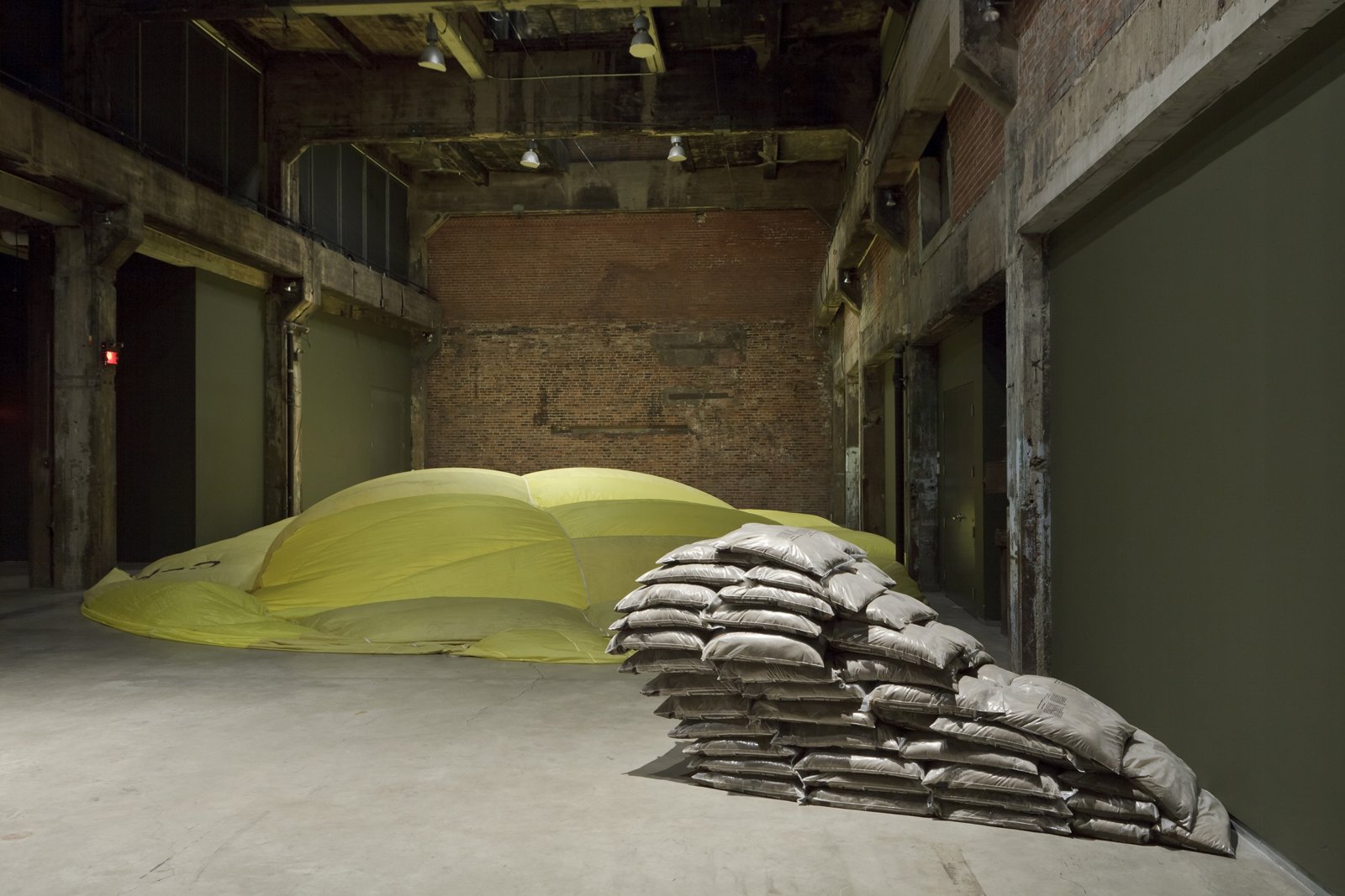 Abbas Akhavan, Like a bat working afraid of its own shadow, 2012, stacked sandbags, 118 x 79 x 59 in. (300 x 200 x 150 cm). Installation view, Beacon, Darling Foundry, Montreal, Canada, 2012