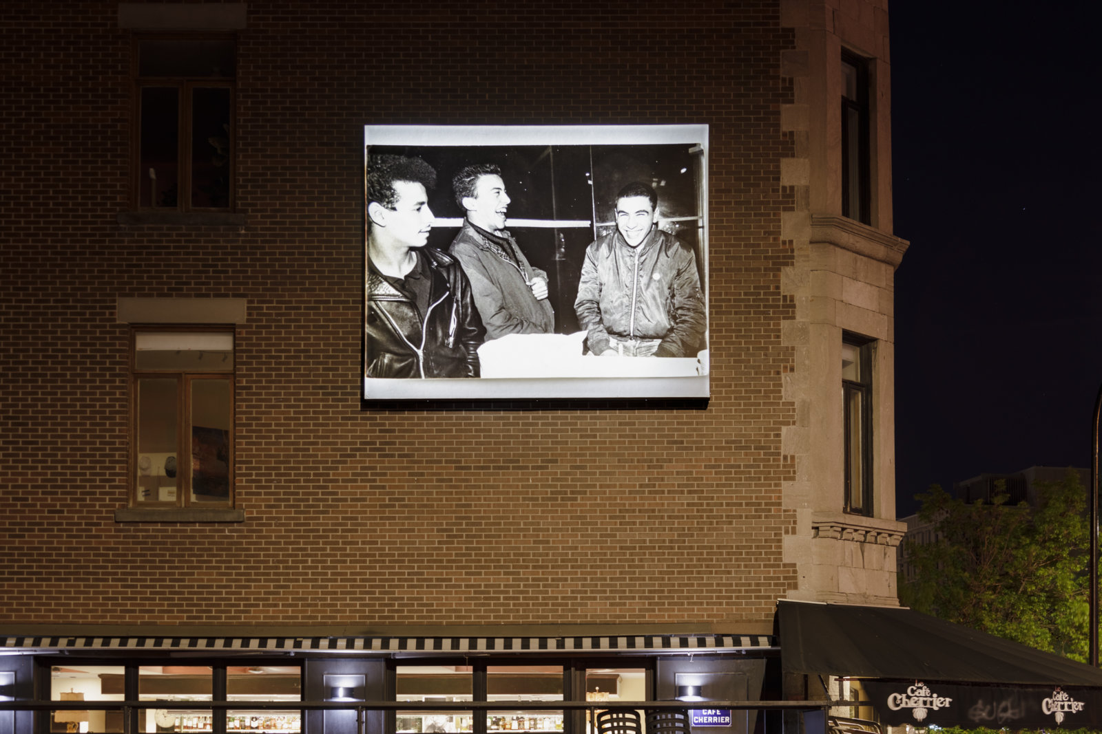 Abbas Akhavan, Omay, Djamal, Albert. hiver 1982, 2023, digital inkjet print on billboard. Installation view, Café Cherrier, Dazibao Satellite, Montreal, Canada, 2023