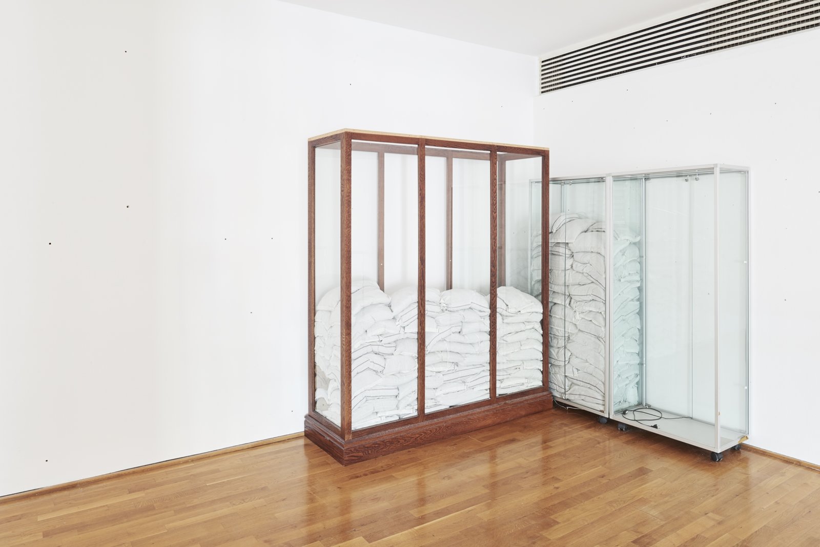 Abbas Akhavan, Untitled, 2017, vitrines, sandbags, insulation, 83 x 71 x 24 in. (210 x 180 x 60 cm) and 71 x 63 x 16 in. (180 x 160 x 40 cm). Installation view, Museum Villa Stuck, Munich, Germany, 2017