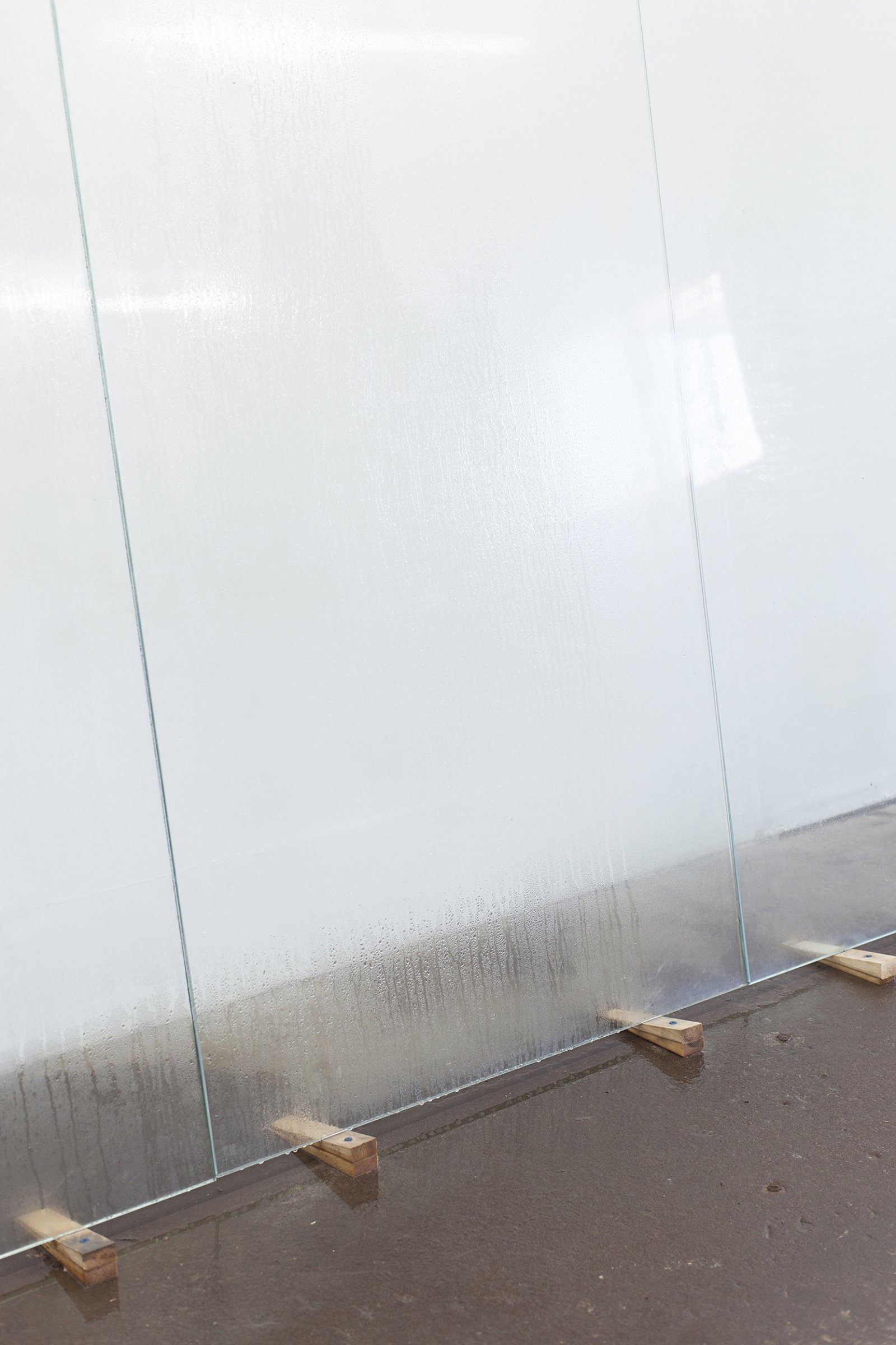 Abbas Akhavan, Untitled (detail), 2018, tempered glass, laser printed photographs, cellophane tape, misting system, water, wood shims, 212 x 96 x 24 in. (539 x 244 x 61 cm). Installation view, Folly, Vie d’ange, Montreal, 2018