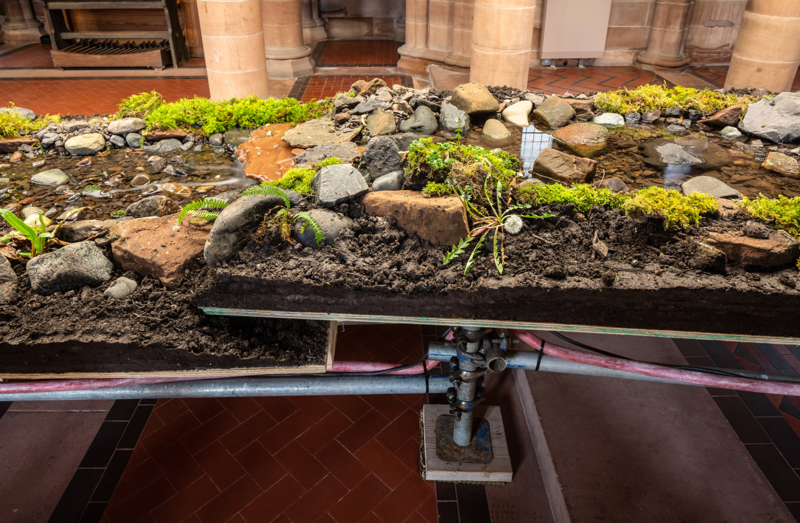 Abbas Akhavan, variations on a folly (detail), 2022, scaffold, plywood, pond liner, aggregate, clay, garden silt, soil, rocks, water, pond pump and tubing, plants sourced from the gardens, hardware, full spectrum lights, installation dimensions variable