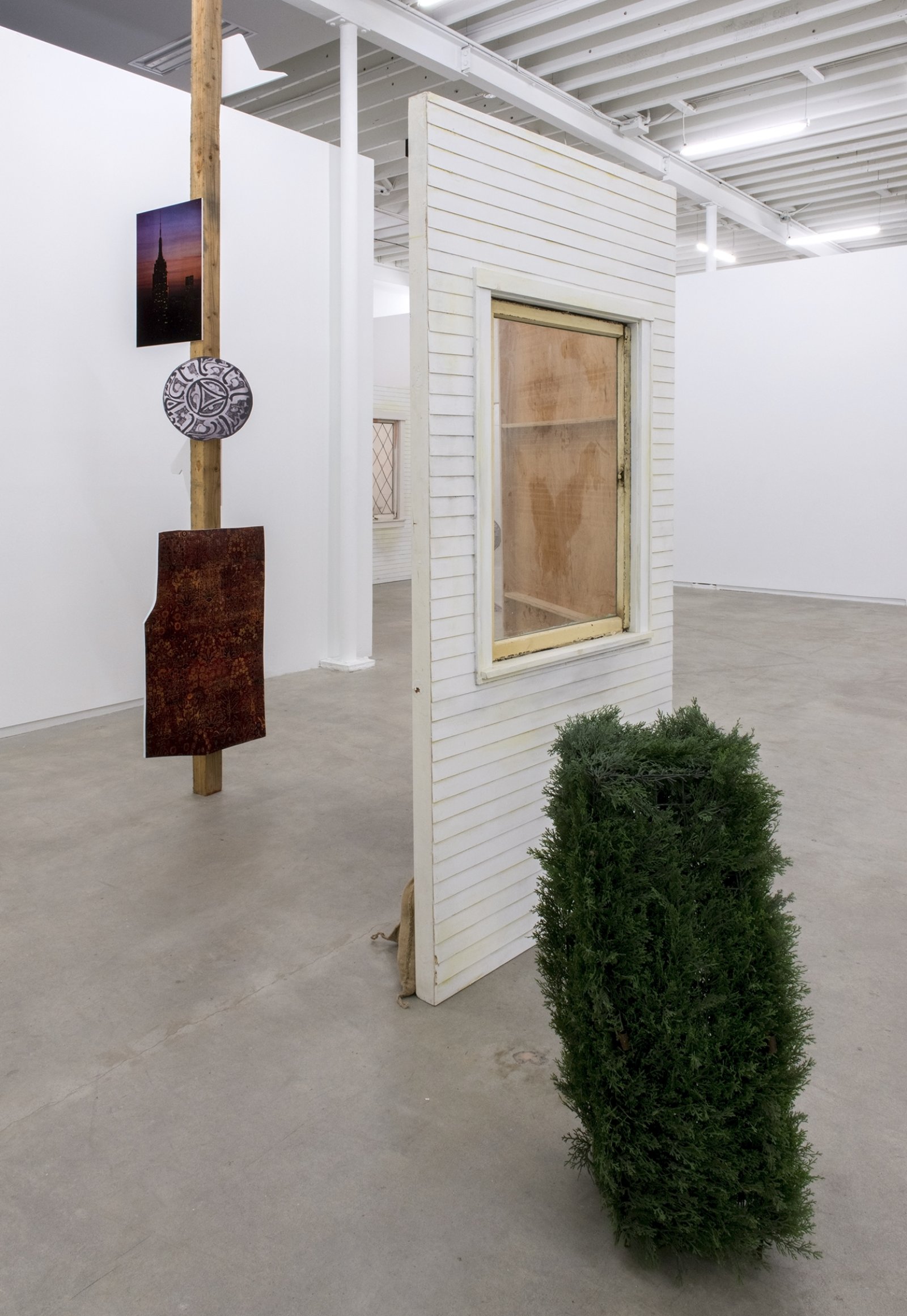 Geoffrey Farmer, This is where the plate goes..., 2014, douglas fir pole, 7 photographs mounted on foamcore, plastic topiary, 2 wooden wall façades, paint, window, sandbags, framed ink and cut-outs mounted on paper, dimensions variable by Geoffrey Farmer
