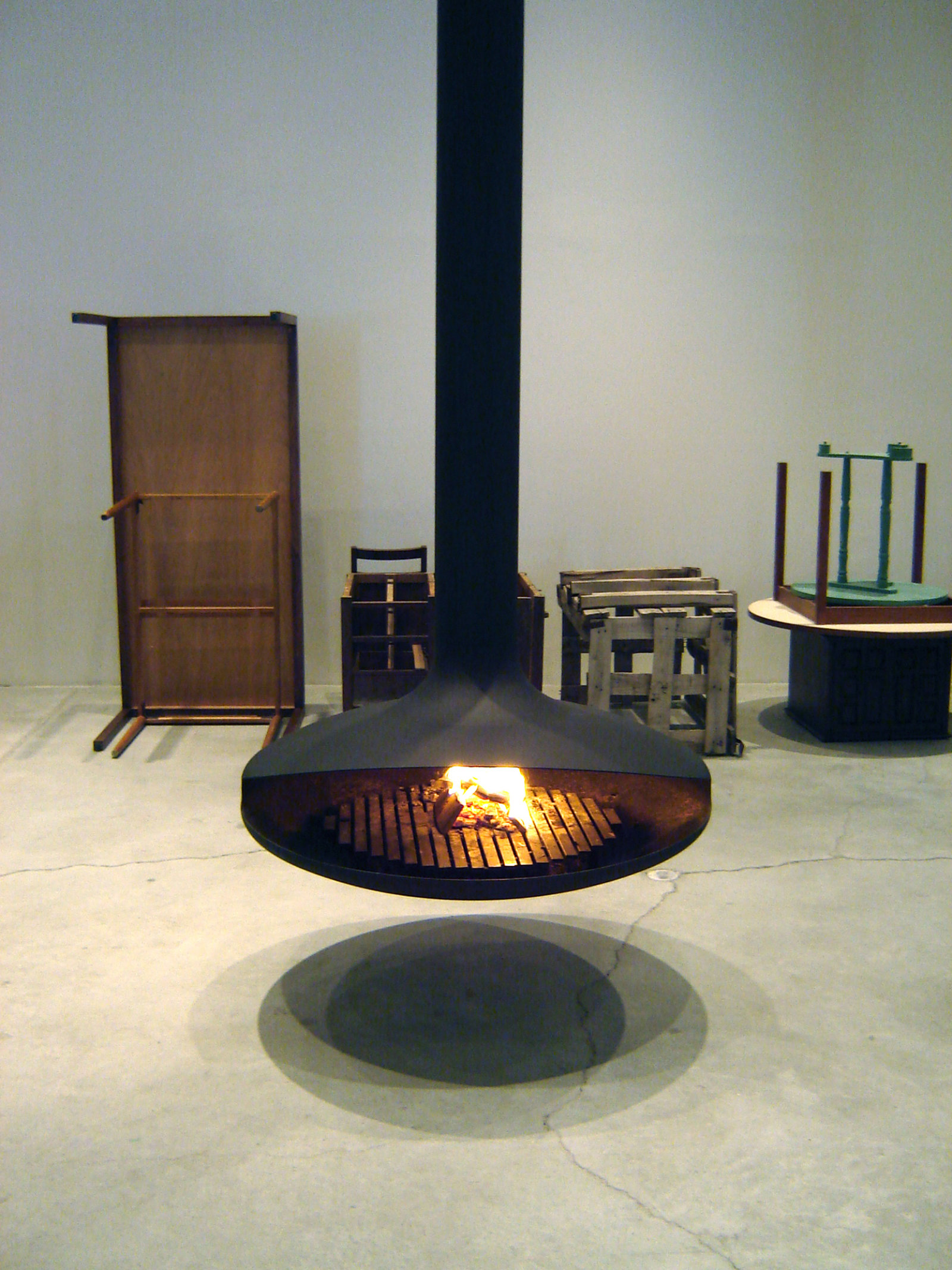 Geoffrey Farmer, A Pale Fire Freedom Machine, 2005, Dominique Imbert fireplace, rubber stamp and inking supplies, numerous inventory of tools and workshop supplies (such as wood benches, chop saw, vice, sand blaster, wooden boxes, stump, axes and various tools), inventory booklet of visuals and description, dimensions variable. Installation view, The Power Plant, Toronto, 2005