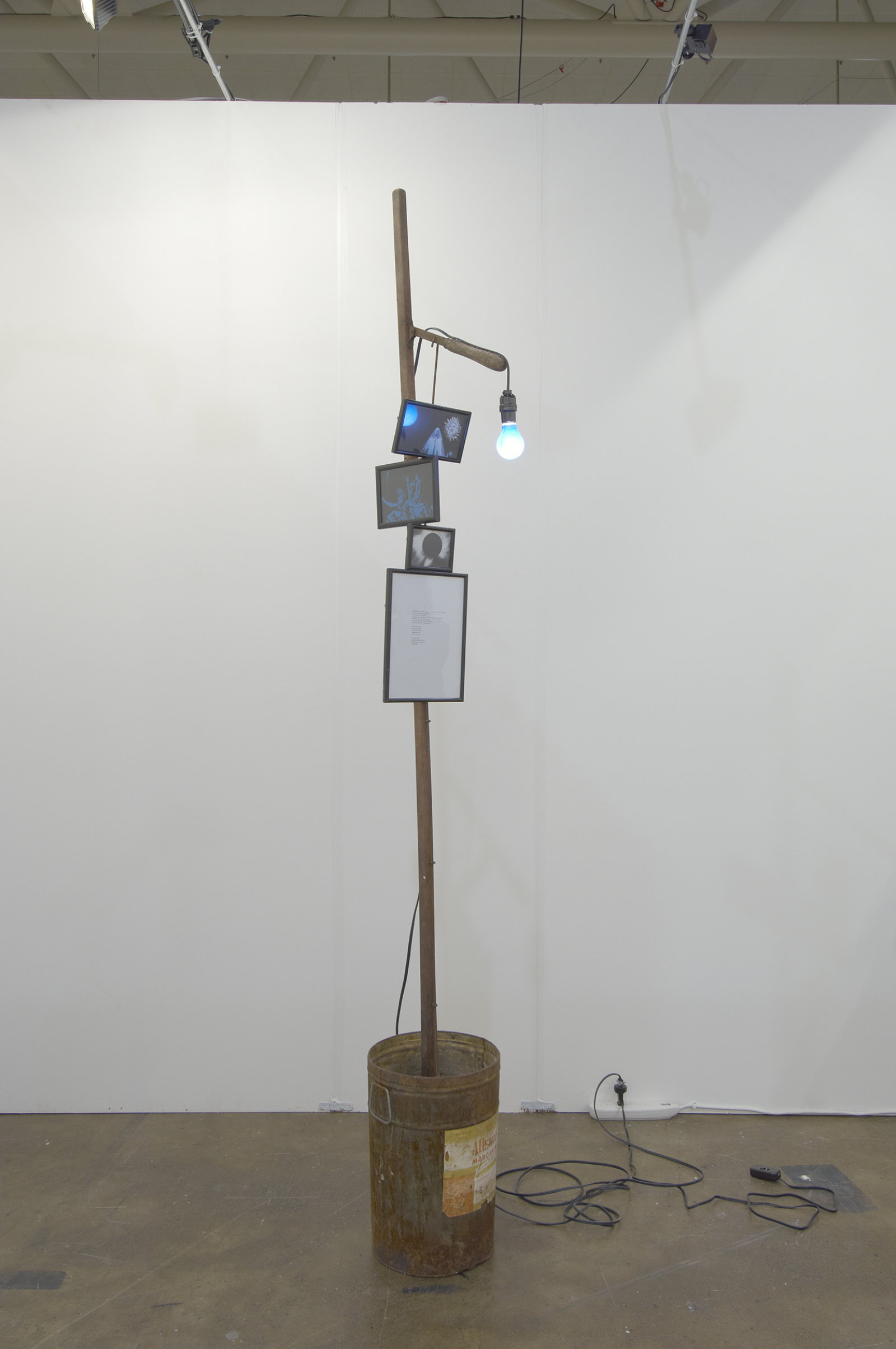 Geoffrey Farmer, I am by nature one and also many, dividing the single me into many, and even opposing them as great and small, light and dark, and in ten thousand other ways, 2006–2008, pruning pole, margarine bucket, concrete, poem, framed pictures, blue light, 97 x 18 x 12 in. (246 x 46 x 31 cm)