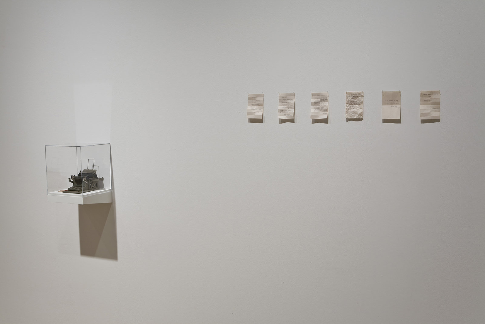 Geoffrey Farmer, Notes For Strangers, 1989–1990, small typewriter, 6 typewritten notes on paper, transfer ticket, shelf with plexiglass top, dimensions variable
