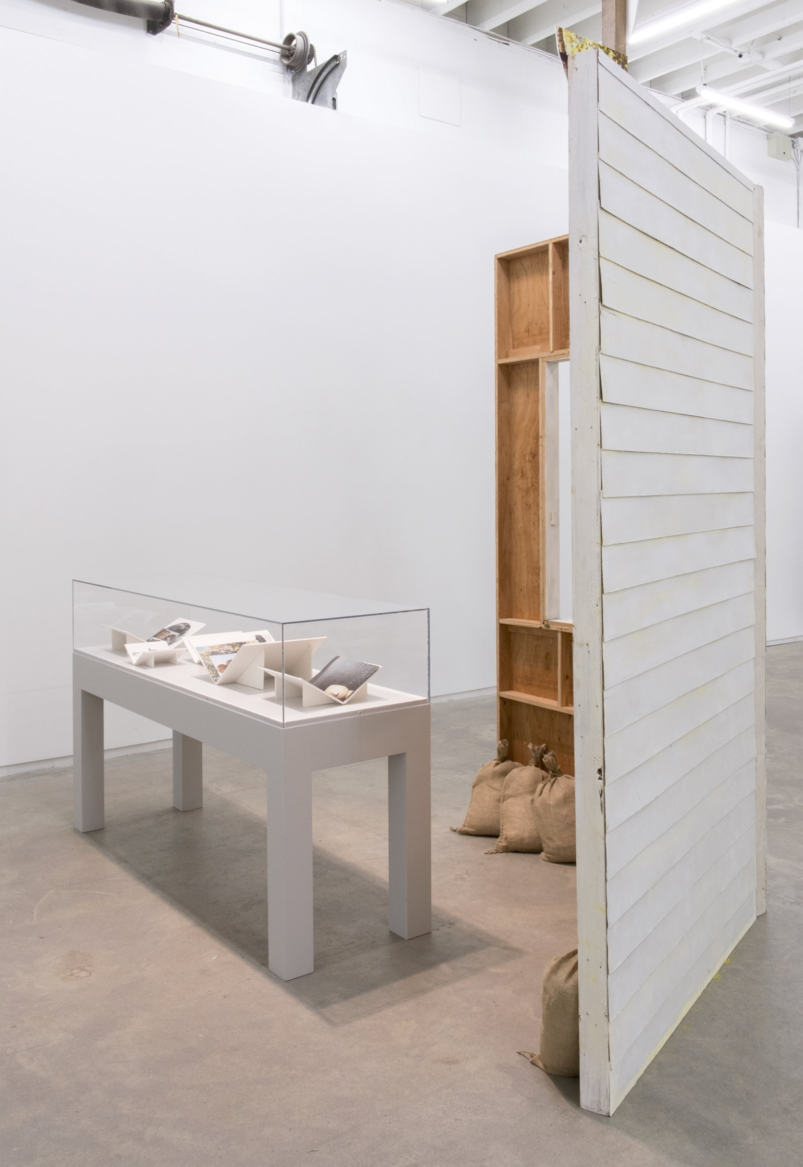 Geoffrey Farmer, Workbooks with When I got fired from that Beckett Play (Fountain), 2014, vitrine with 5 cut-outs collaged on foamcore, 2 wooden wall façades, paint, window, sandbags, framed cut-outs and ink mounted on paper, dimensions variable