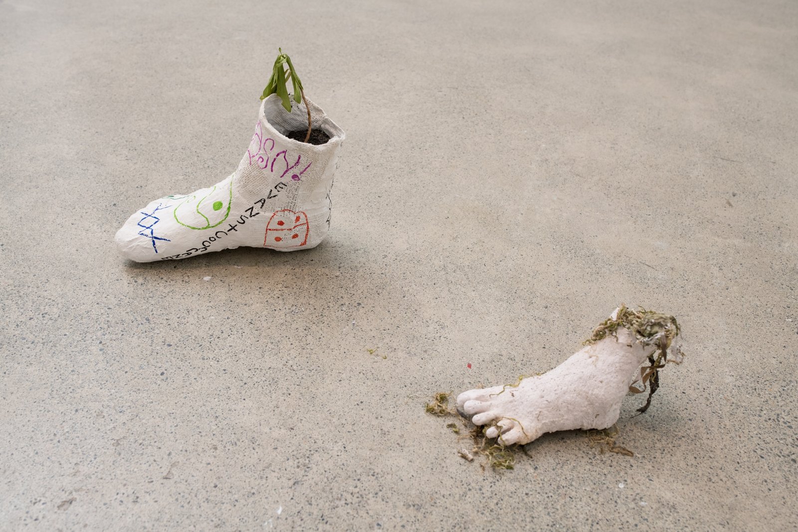 Kasper Feyrer, Propagators (detail), 2019, silicone, stones, plaster, alginate, Ulva intestinalis (gutweed), permanent marker on plaster bandage, coal slack, soil, Daphne laureola (spurge laurel), found objects, 19 x 138 x 24 in. (48 x 351 x 19 cm)