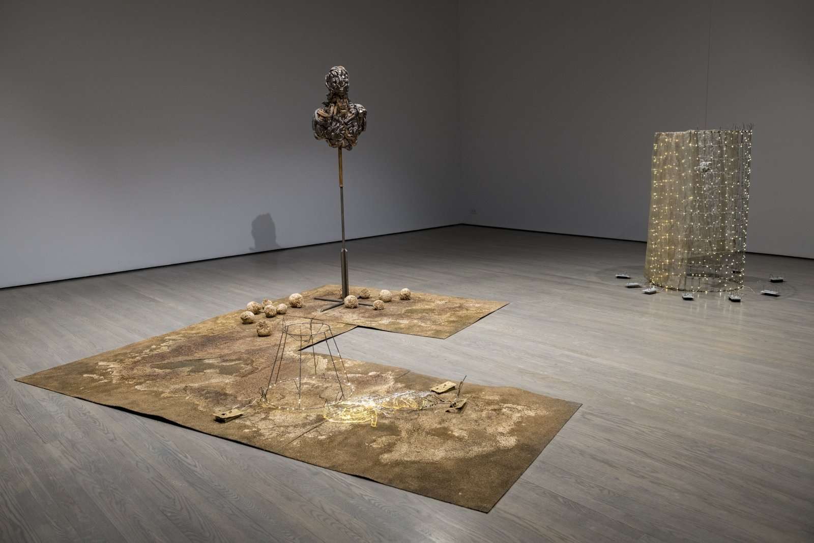 Rochelle Goldberg, Intralocutor: can you trigger the switch?, 2018, brass, bronze, batteries, dispersion paint, shellac, celery root, chia, acrylic medium, steel, led, polyester carpet, resin, glazed ceramic, 72 x 109 x 110 in. (182 x 276 x 279 cm). Installation view, In the No Longer Not Yet, Leonard and Bina Ellen Art Gallery, Montreal, 2020