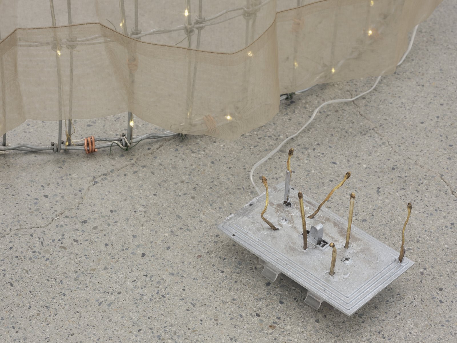 Rochelle Goldberg, Trigger: Towards everything they’ve ever wanted (detail), 2019, ranch fencing, batteries, fairy lights, polyester curtain, aluminum, cast bronze matches, copper wire, 51 x 51 x 44 in. (130 x 130 x 112 cm)