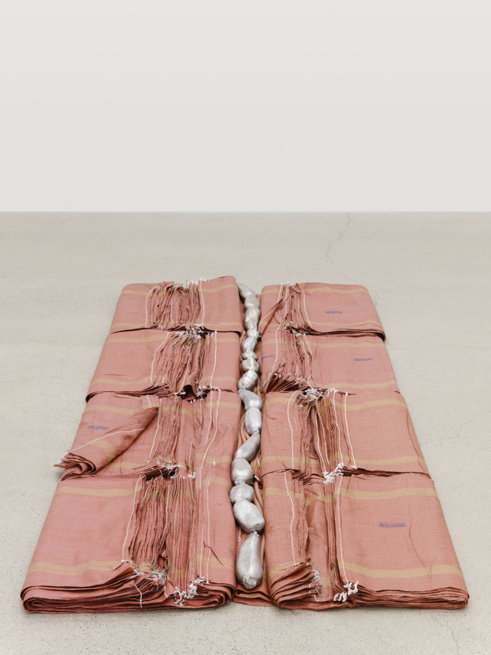 Laurie Kang,  Scaffold, 2022, construction bags, cast aluminum lotus root, pigmented silicone, 4 1/2 x 46 x 111 in. (11 x 117 x 282 cm) by 