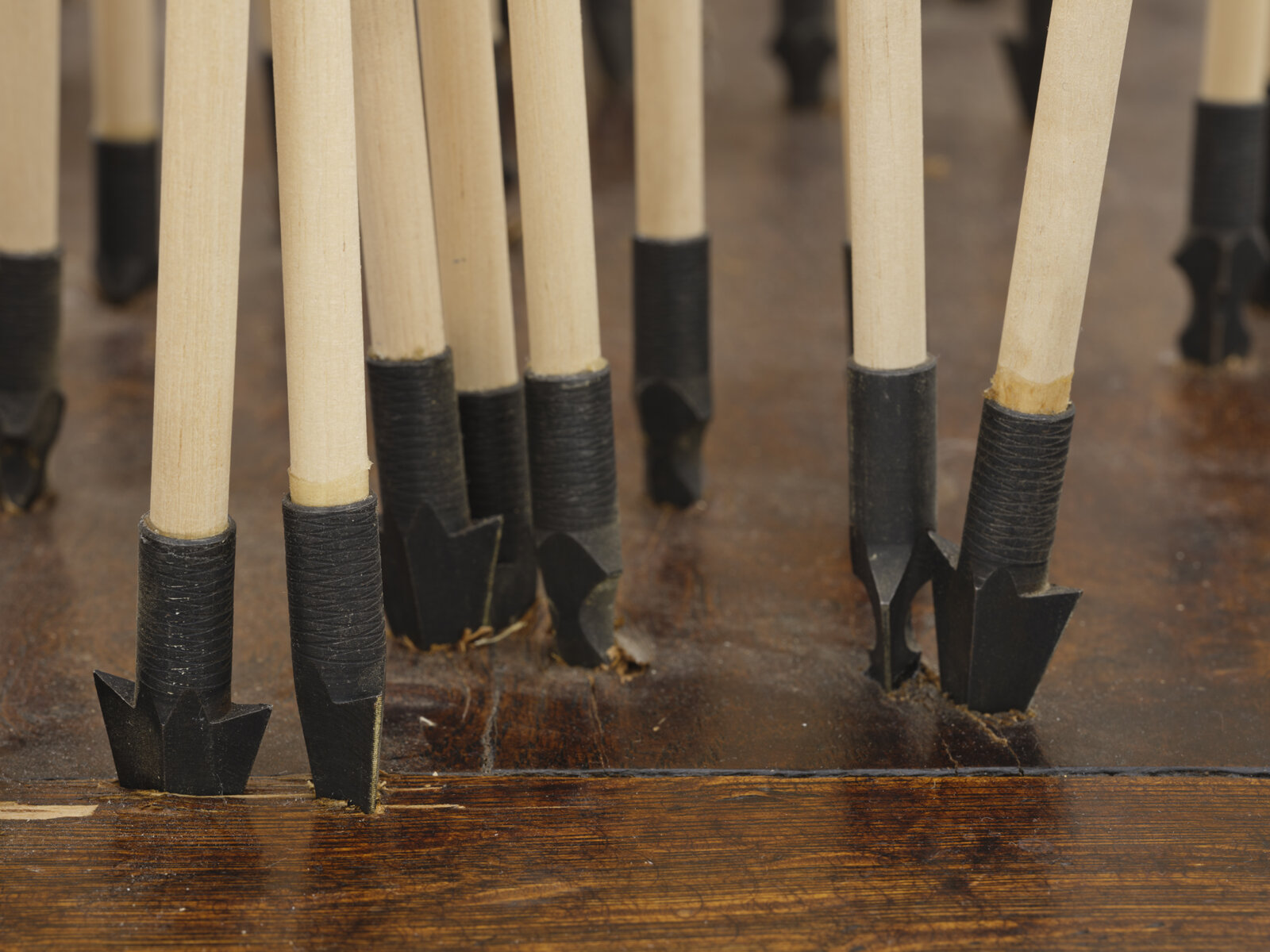 Brian Jungen, The Way of the World (detail), 2024, 250-year-old French colonial oak table from Baton Rouge, wood arrows, carbon steel points, feather, artificial sinew, 63 x 76 x 29 in. (160 x 193 x 74 cm)