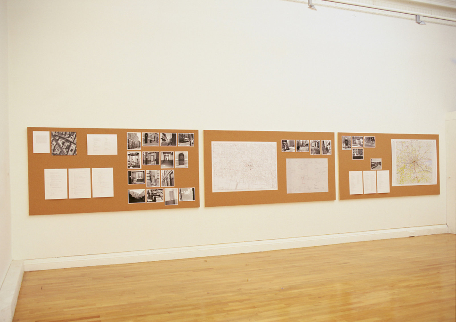 Janice Kerbel, Bank Job, 1999, digital inkjet prints, black and white photographs, aerial photograph, ordnance survey map, blueprint, city map, string, pins, cork, wood, 291 x 47 in. (739 x 119 cm)