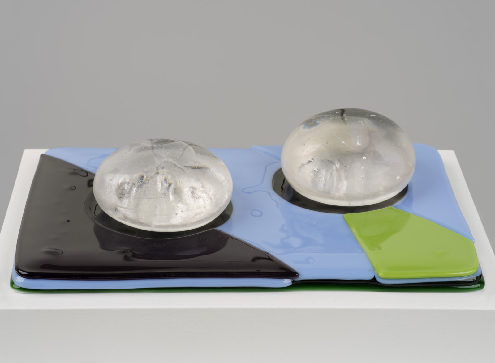 Devon Knowles, Is, Was, Here, 2022, glass, 3 parts, yellow 3 x 10 x 7 in. (6 x 25 x 18 cm); blue 3 x 10 x 7 in. (6 x 25 x 17 cm); mint 2 x 10 x 7 in. (5 x 25 x 18 cm)