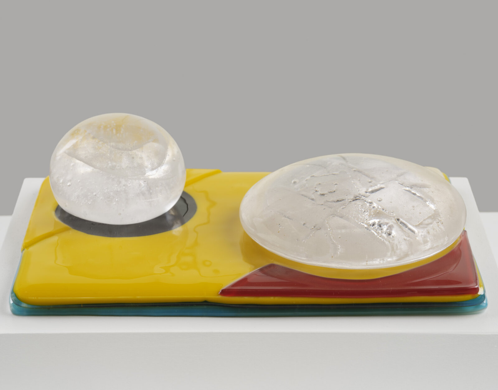 Devon Knowles, Is, Was, Here, 2022, glass, 3 parts, yellow 3 x 10 x 7 in. (6 x 25 x 18 cm); blue 3 x 10 x 7 in. (6 x 25 x 17 cm); mint 2 x 10 x 7 in. (5 x 25 x 18 cm)