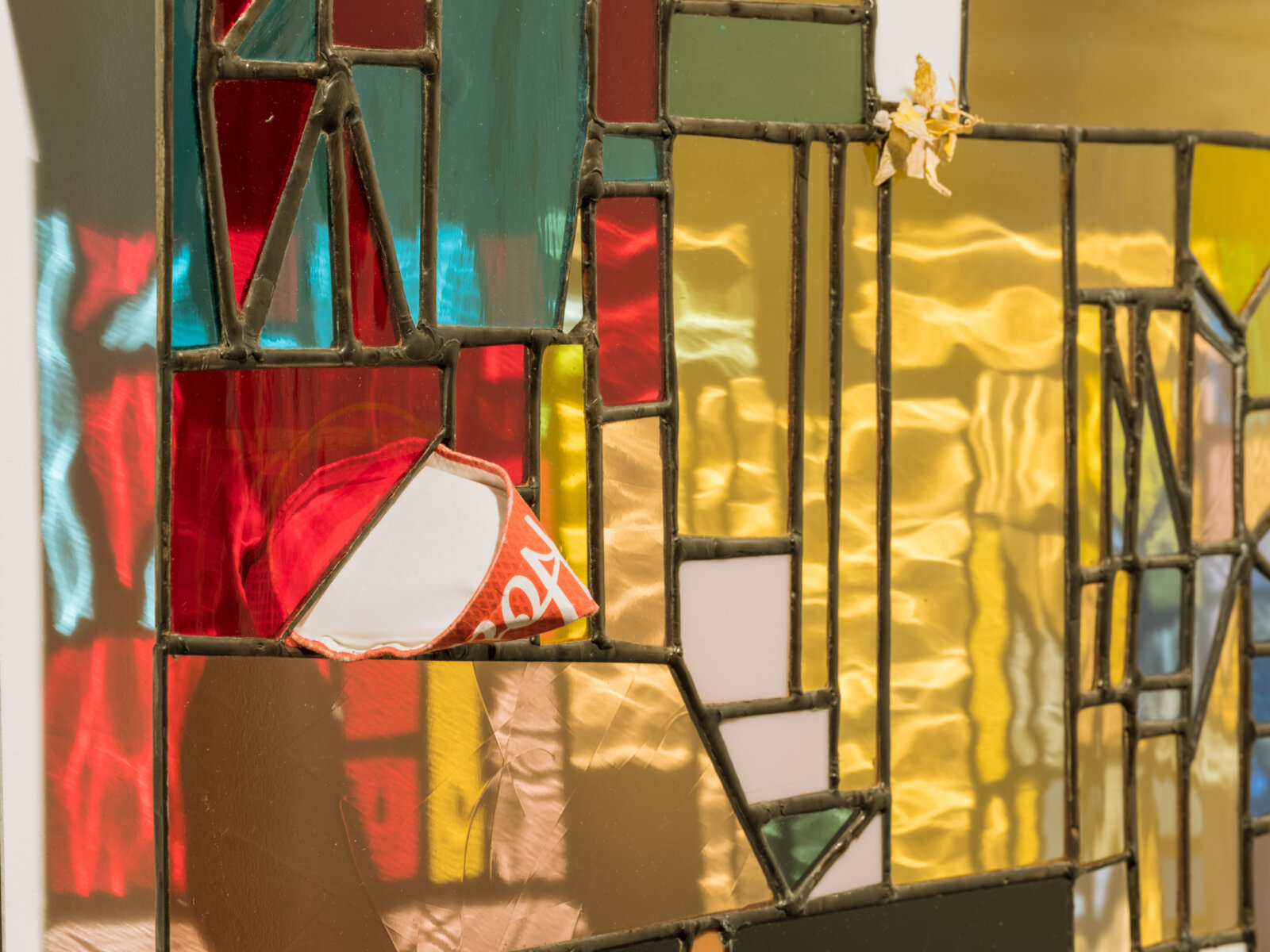 Devon Knowles, Walking Spectrum II, i, S17 (detail), 2018, glass, flower petals, iPod glass, paper cup, felt pen, reusable adhesive putty, lead, tin, steel, paint, 20 x 20 x 3 in. (51 x 51 x 8 cm)