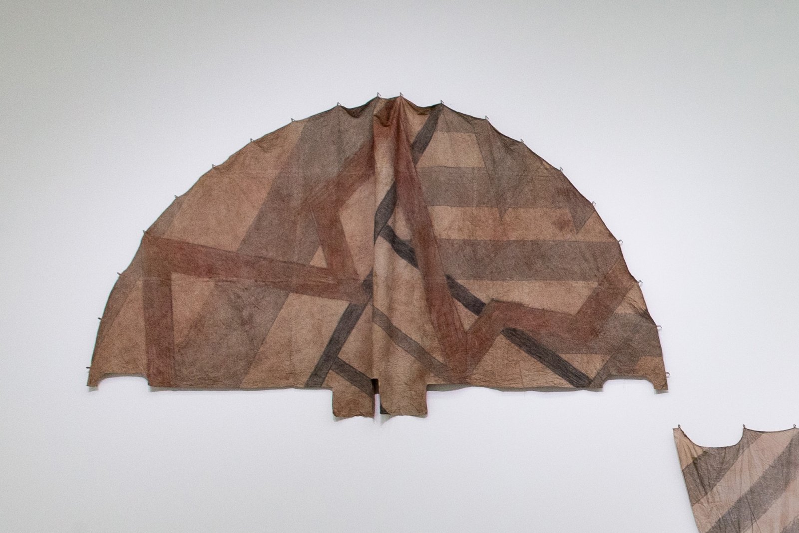 Duane Linklater, Tipi cover for new old geometries / little door for Sassa, 2018, digital print on hand-dyed linen, sumac, charcoal, nails, 110 x 210 in. (278 x 533 cm). Installation view, Post-Nature—A Museum as an Ecosystem, Taipei Biennial 2018, Taipei Fine Arts Museum, Taiwan, 2018