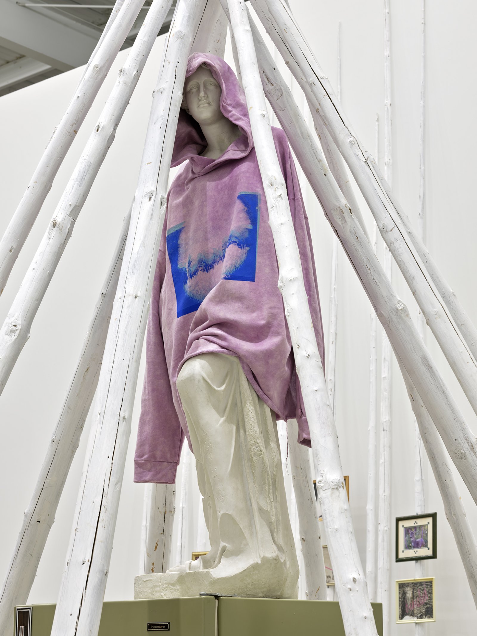 Duane Linklater, what grief conjures (detail), 2020, teepee poles, paint, nylon rope, wooden pallet, refrigerator, tie-down straps, hand truck, plastic statue, handmade hoodie, cochineal dye, silkscreen, 249 x 160 x 160 in. (632 x 406 x 406 cm)