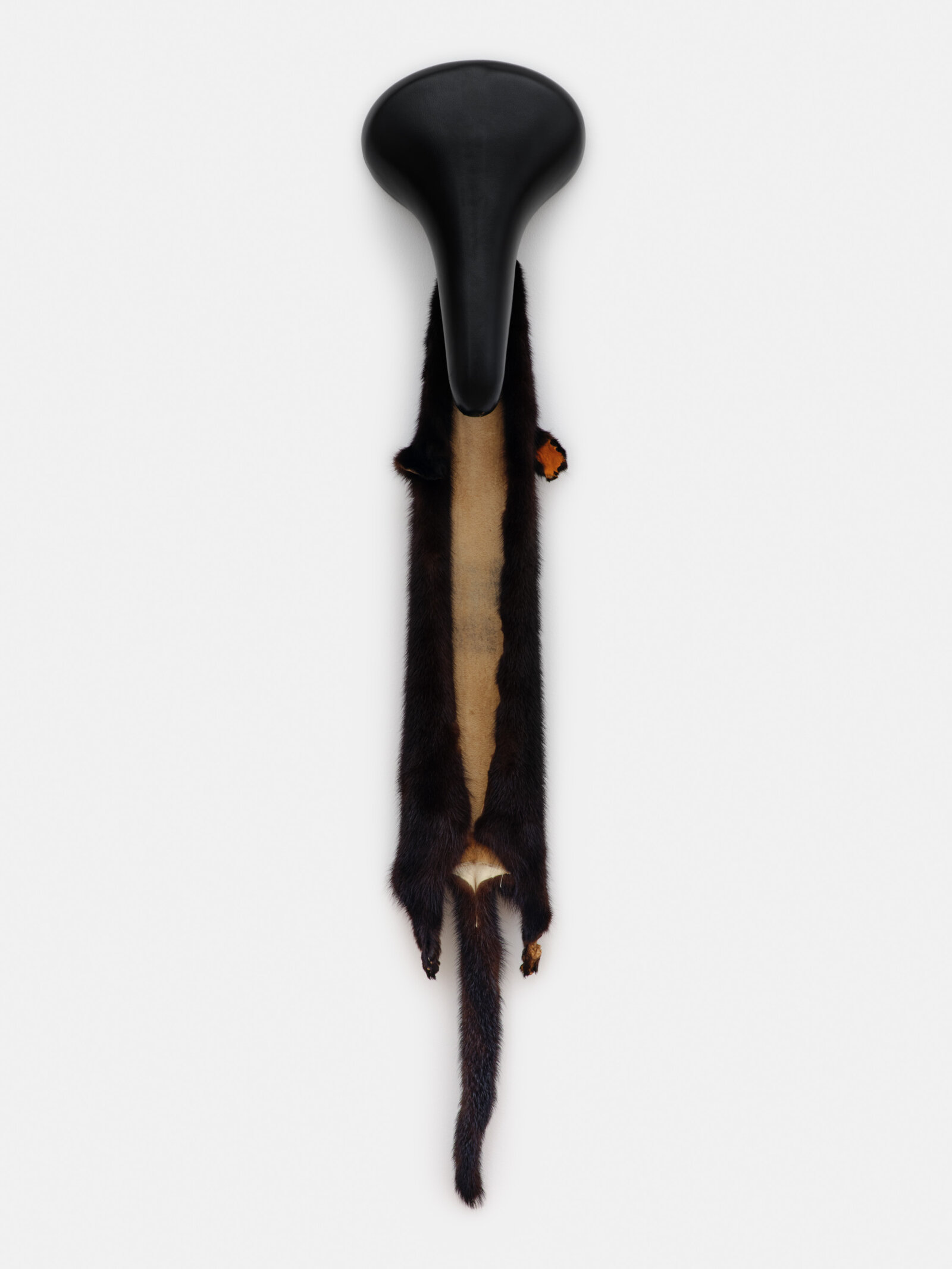 Duane Linklater, orangepaw (for nikawiy), 2023, mink fur, bicycle seat, paint, 35 x 7 x 5 in. (89 x 18 x 12 cm)