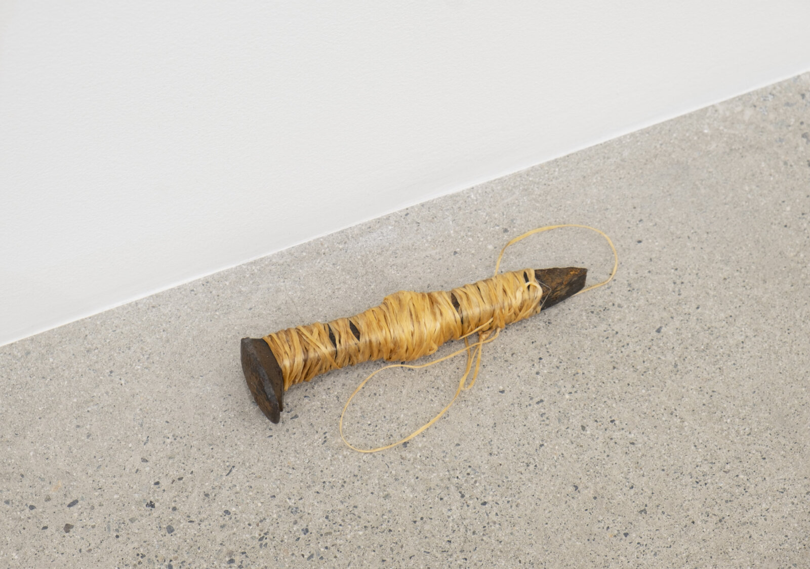 Duane Linklater, woundedknee, 2023, rail spike, sinew, 7 x 2 x 2 in. (17 x 4 x 5 cm)