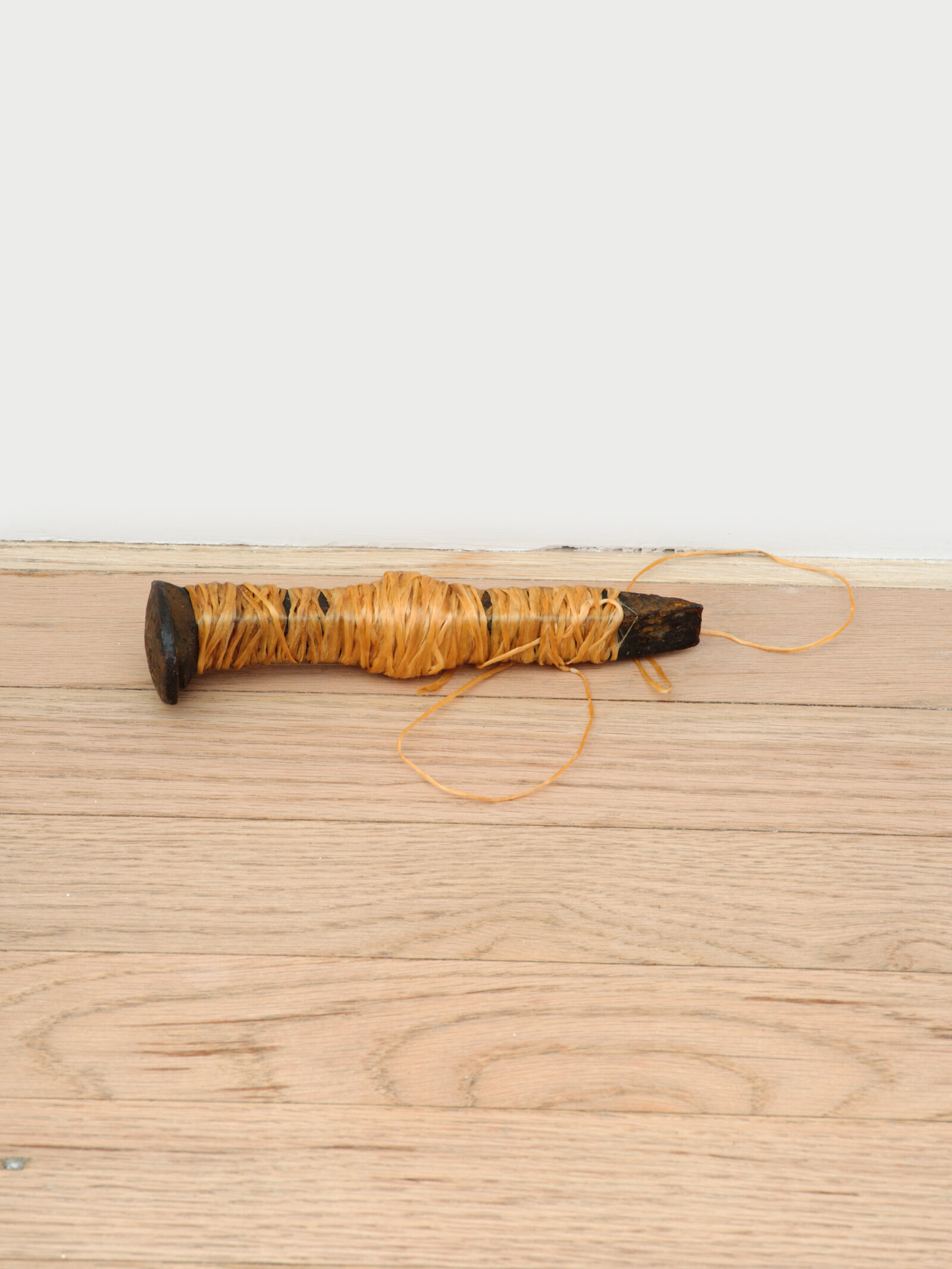 Duane Linklater, woundedknee, 2023, rail spike, sinew, 7 x 2 x 2 in. (17 x 4 x 5 cm)