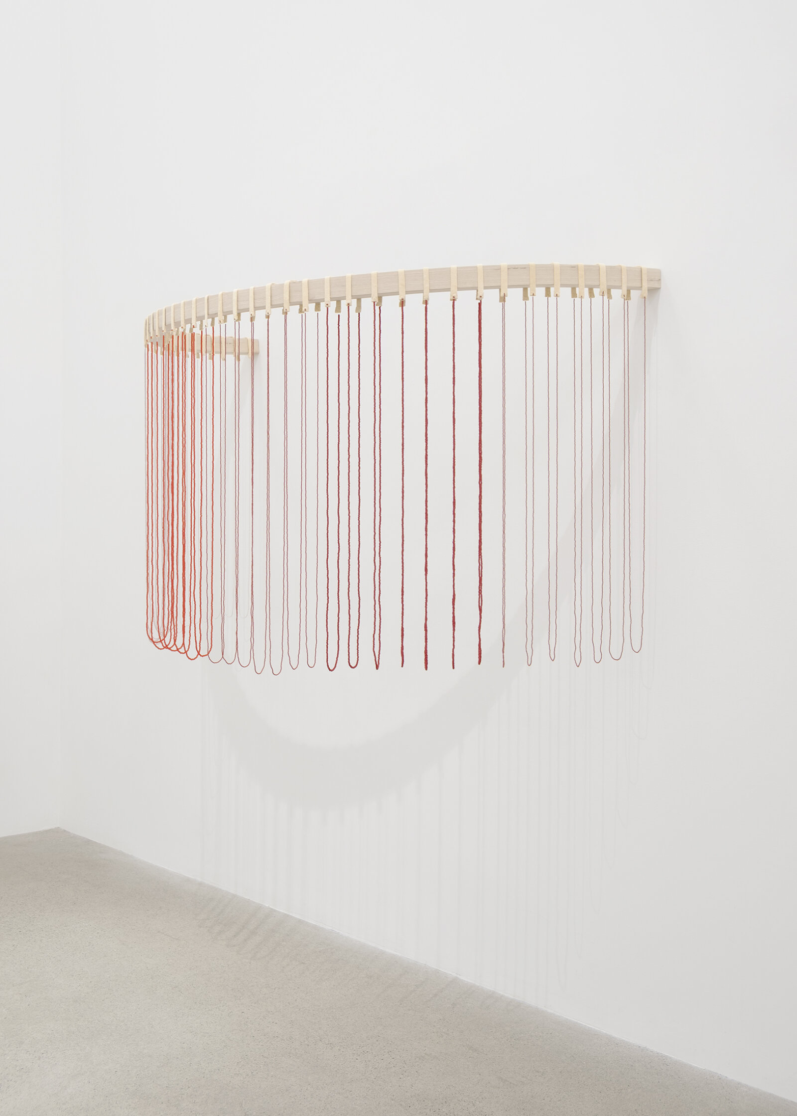 Tanya Lukin Linklater, ochre-smeared earth, 2026, 42 circular beaded strands, bentwood ash, seed beads, thread (fishing line), deer hide, 35 x 68 x 29 in. (89 x 173 x 72 cm)