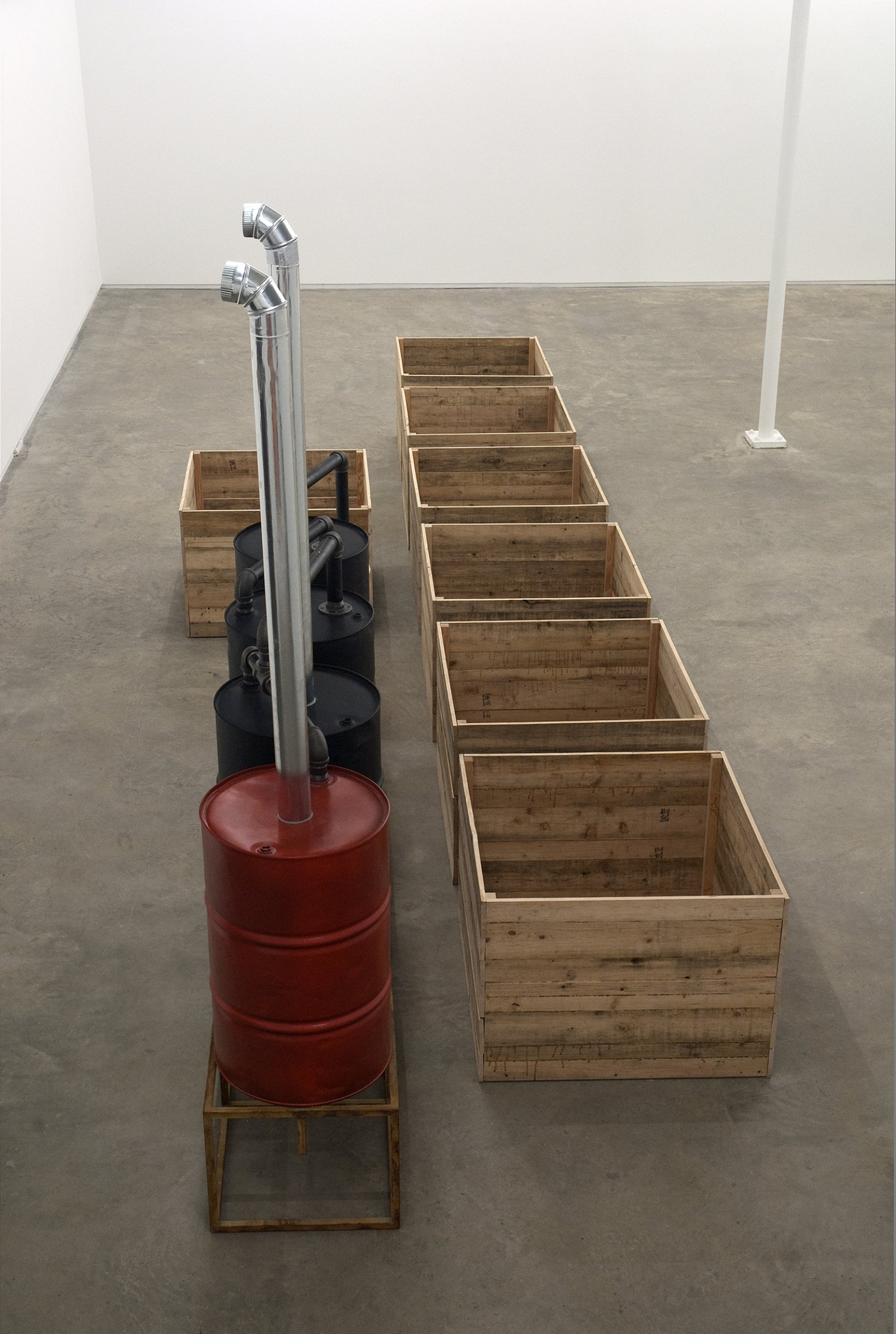 ​Myfanwy MacLeod, Everything Seems Empty Without You, 2009, metal oil drums, metal sand, metal pipes, wooden boxes, wooden barrel, 118 x 332 x 94 in. (300 x 843 x 239 cm) by 