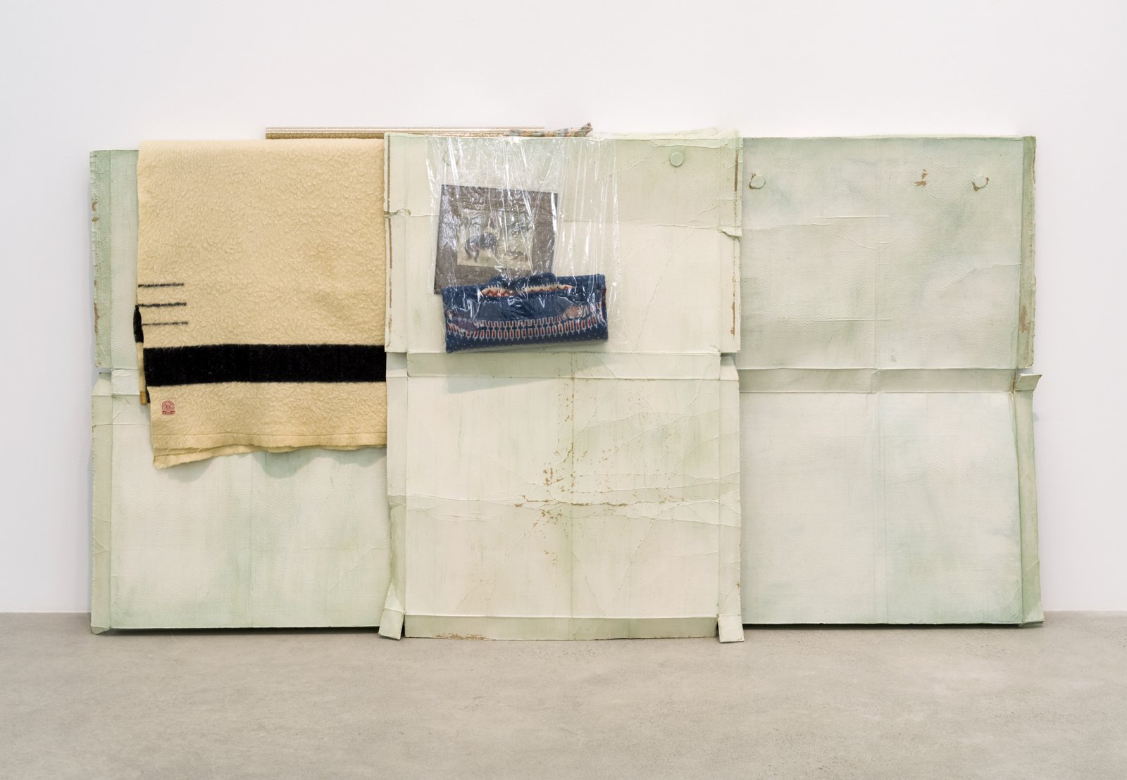 Liz Magor, Good Shepherd, 2016, polymerized gypsum, wool, plastic bags, plastic sheet, cardboard, 53 x 103 x 12 in. (133 x 262 x 31 cm) by Liz Magor