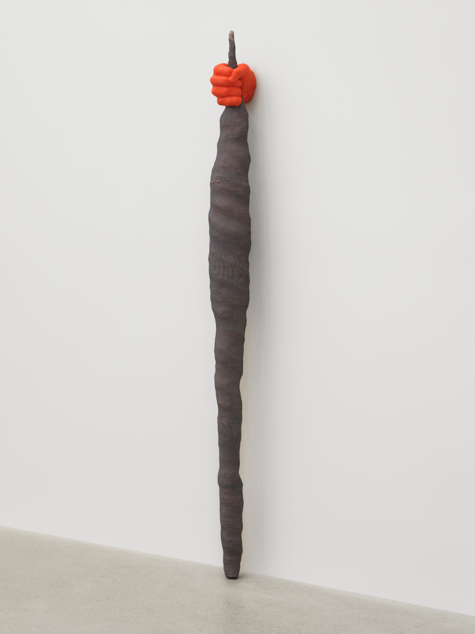 Liz Magor, Fist (orange), 2025, silicon rubber, polyester mesh, upholstery tacks, 84 x 9 x 6 in. (213 x 22 x 15 cm)