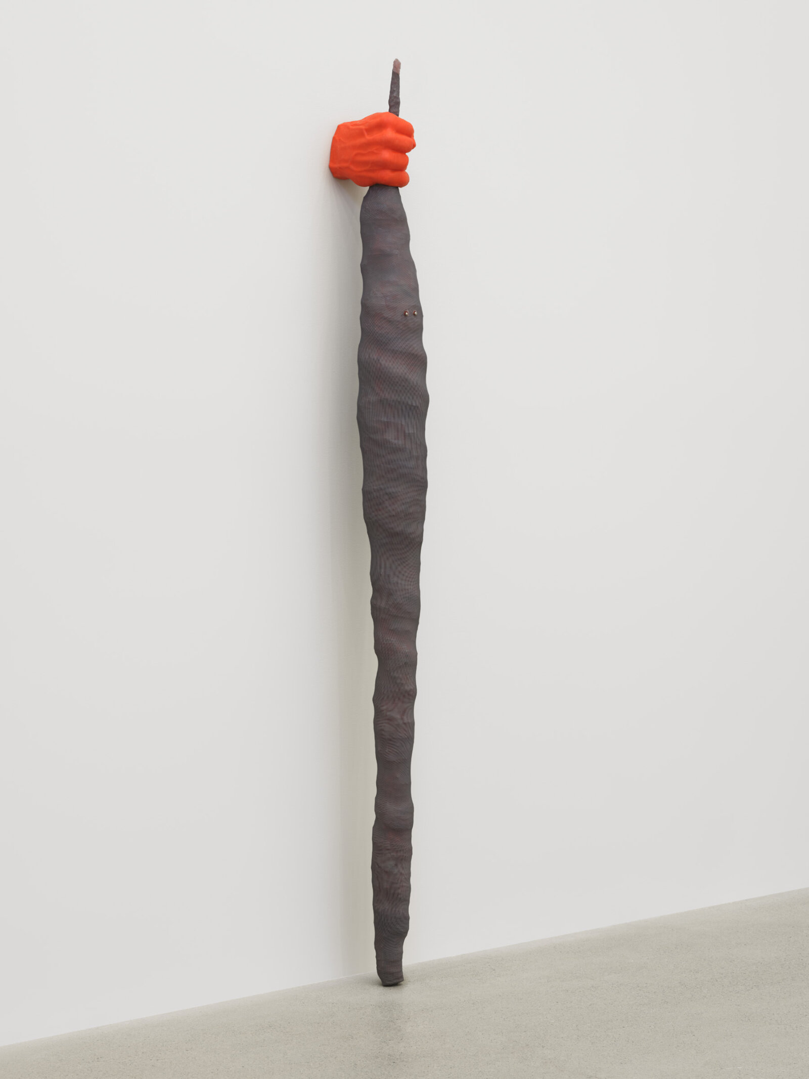 Liz Magor, Fist (orange), 2025, silicon rubber, polyester mesh, upholstery tacks, 84 x 9 x 6 in. (213 x 22 x 15 cm)