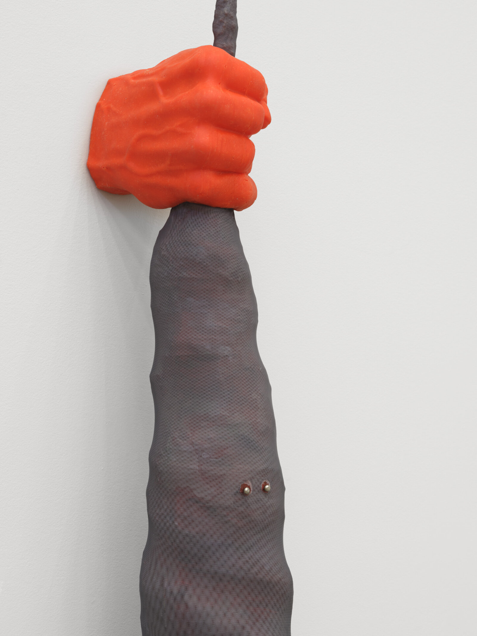 Liz Magor, Fist (orange) (detail), 2025, silicon rubber, polyester mesh, upholstery tacks, 84 x 9 x 6 in. (213 x 22 x 15 cm)