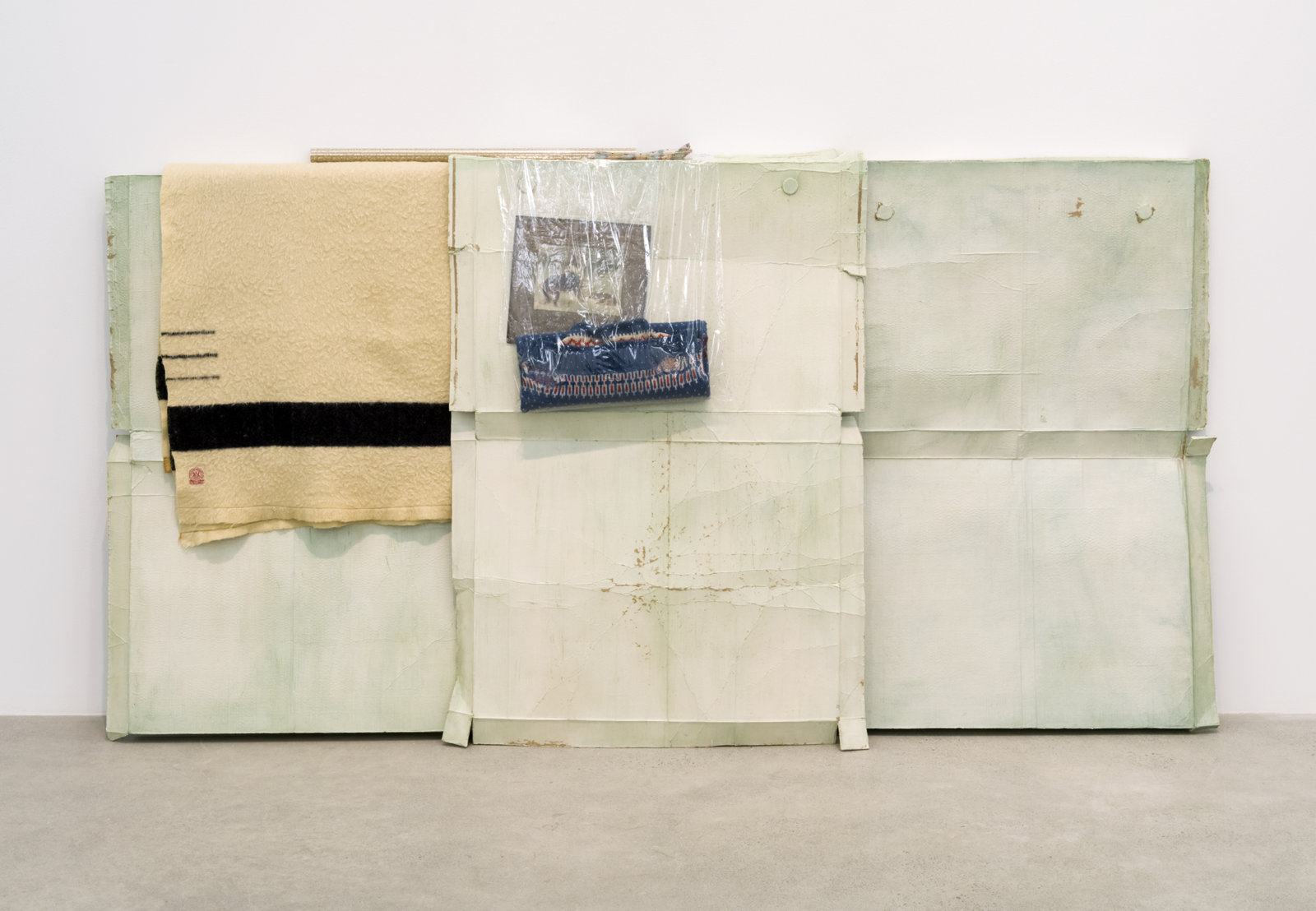 Liz Magor, Good Shepherd, 2016, polymerized gypsum, wool, plastic bags, plastic sheet, cardboard, 53 x 103 x 12 in. (133 x 262 x 31 cm)