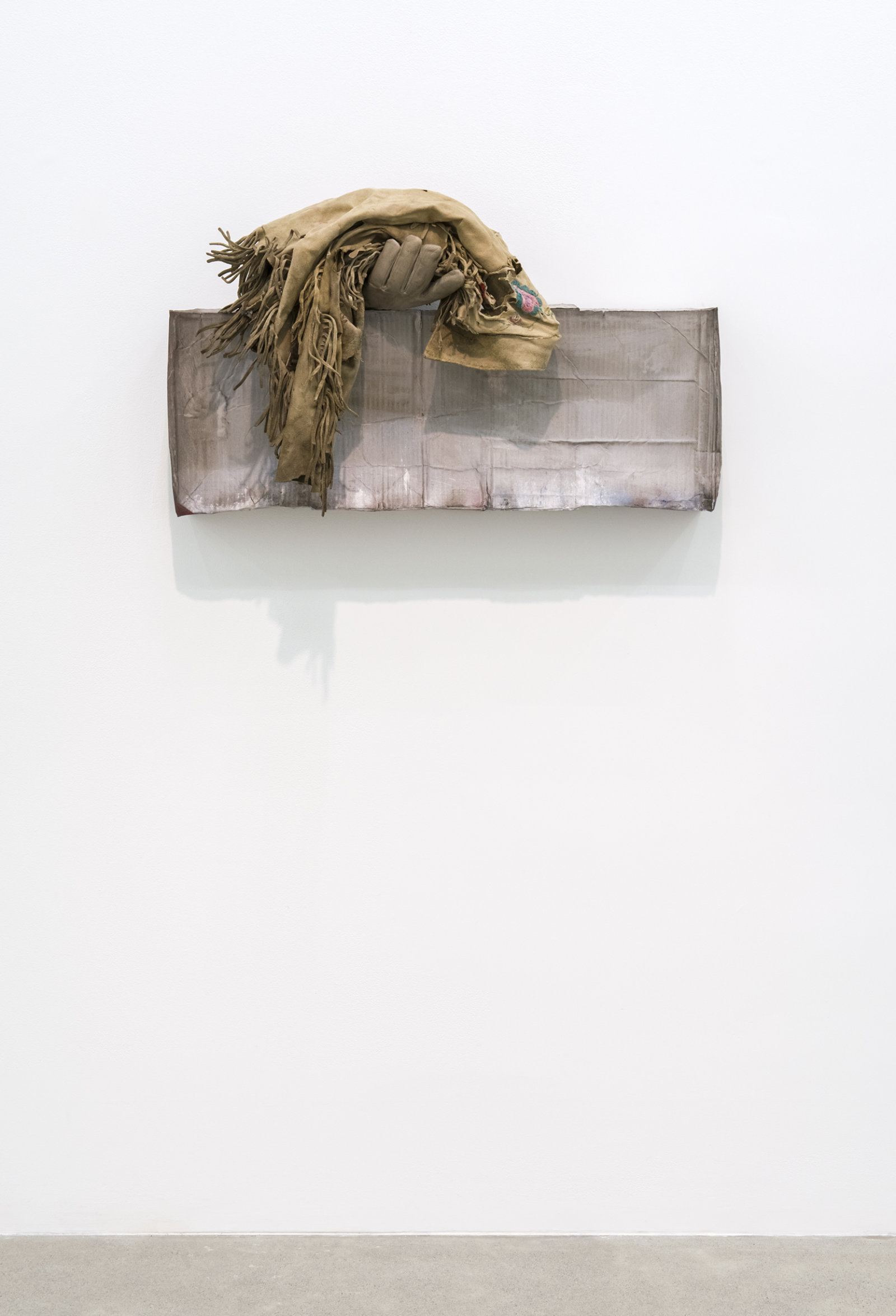 Liz Magor, Still Alive, 2016, polymerized gypsum, deerskin jacket, 19 x 34 x 11 in. (48 x 86 x 27 cm)