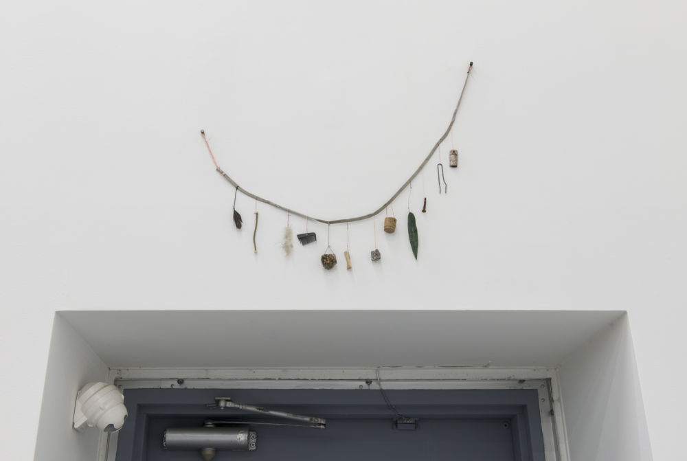 ​Gareth Moore, Reminder (Vancouver), 2013, shoelace, string, copper wire, wood, metal, artificial leaf, cork, stone, bone, burl, comb, cloth, rope, feather, 19 x 22 x 1 in. (47 x 56 x 2 cm) by 
