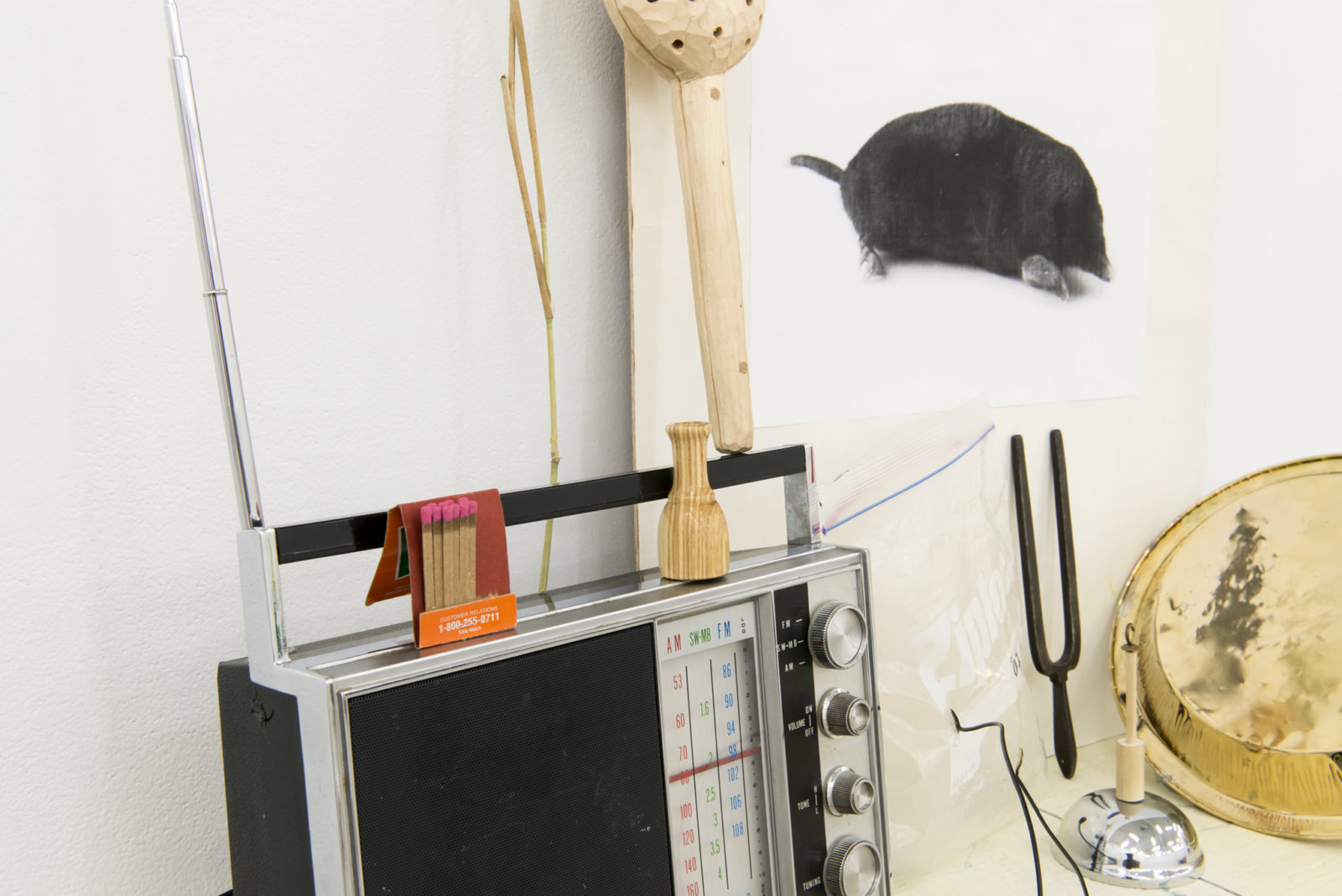 Ashes Withyman, Cetus, Compass, River, Furnas, Musca, Altar, Cup (detail), 2017–2018, radio, matches, animal call, wood and stone rattle, photocopy, grass, usb flash drive, gold plated tin, sand, ziploc bag with contact microphone, tuning fork, dried grass, bell, painted plywood, 52 x 29 x 9 in. (132 x 74 x 23 cm)