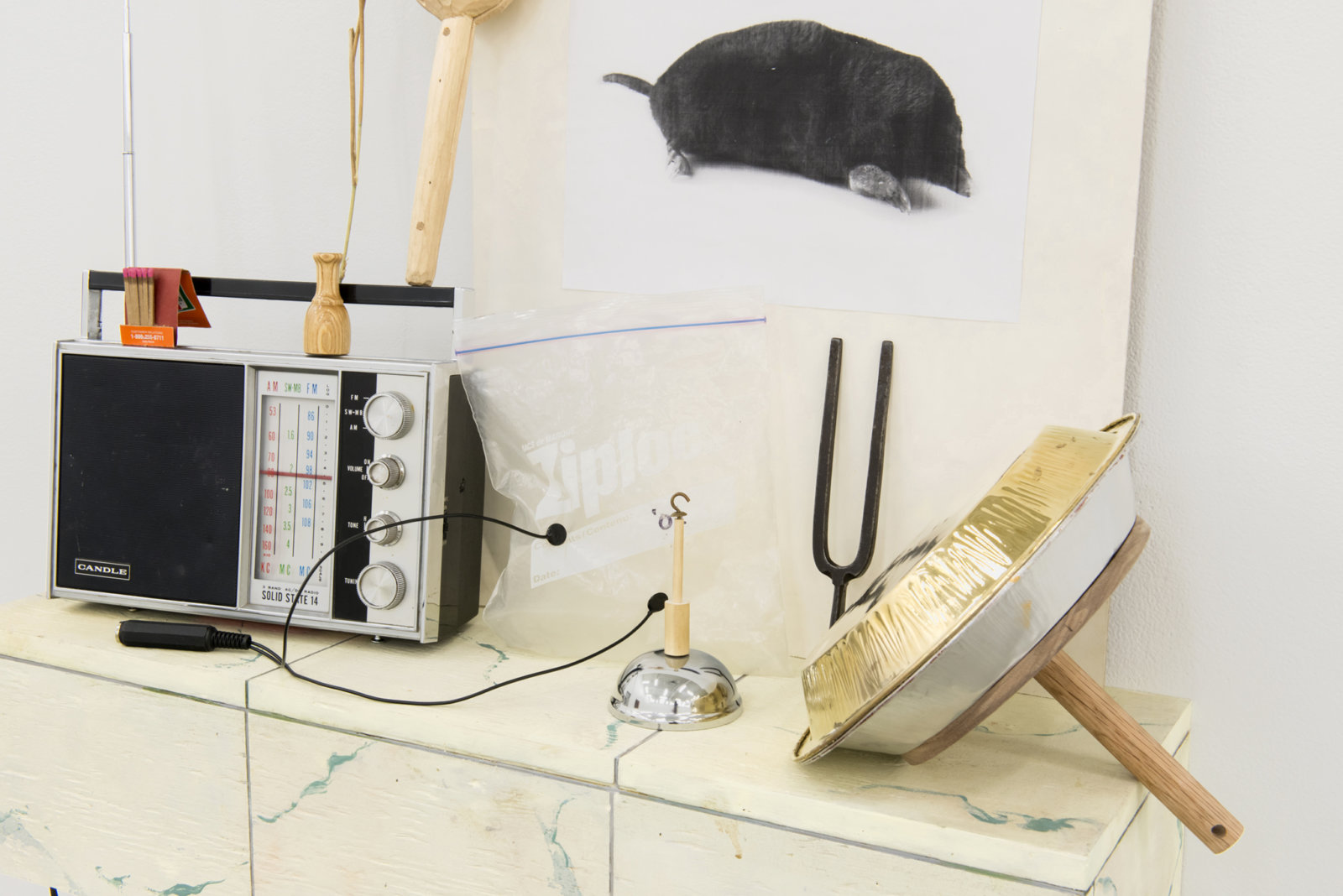 Ashes Withyman, Cetus, Compass, River, Furnas, Musca, Altar, Cup (detail), 2017–2018, radio, matches, animal call, wood and stone rattle, photocopy, grass, usb flash drive, gold plated tin, sand, ziploc bag with contact microphone, tuning fork, dried grass, bell, painted plywood, 52 x 29 x 9 in. (132 x 74 x 23 cm)