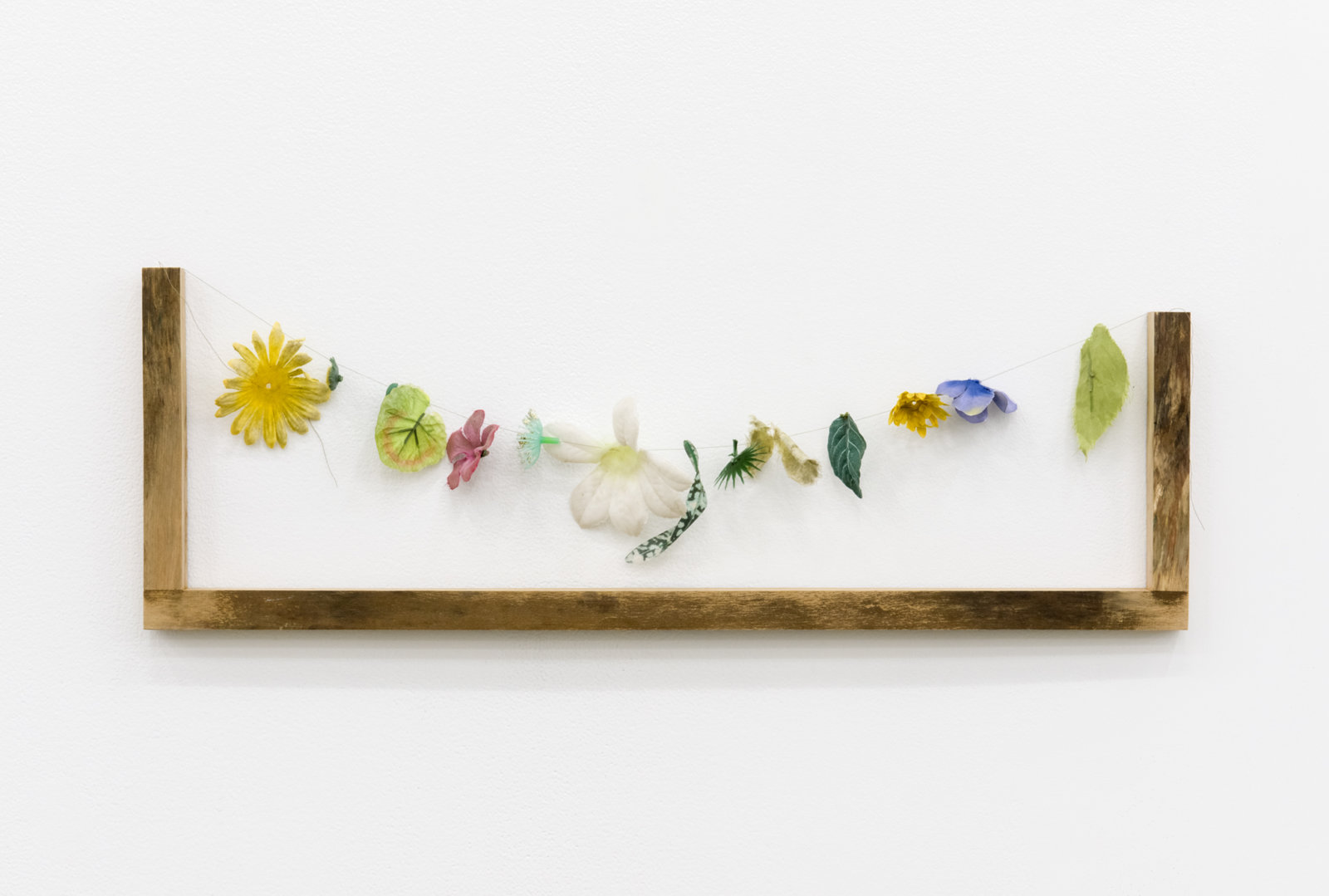 Ashes Withyman, Reminder (Cemetery Island), 2017, plastic flowers, thread, wood, 8 x 25 x 3 in. (21 x 62 x 6 cm)