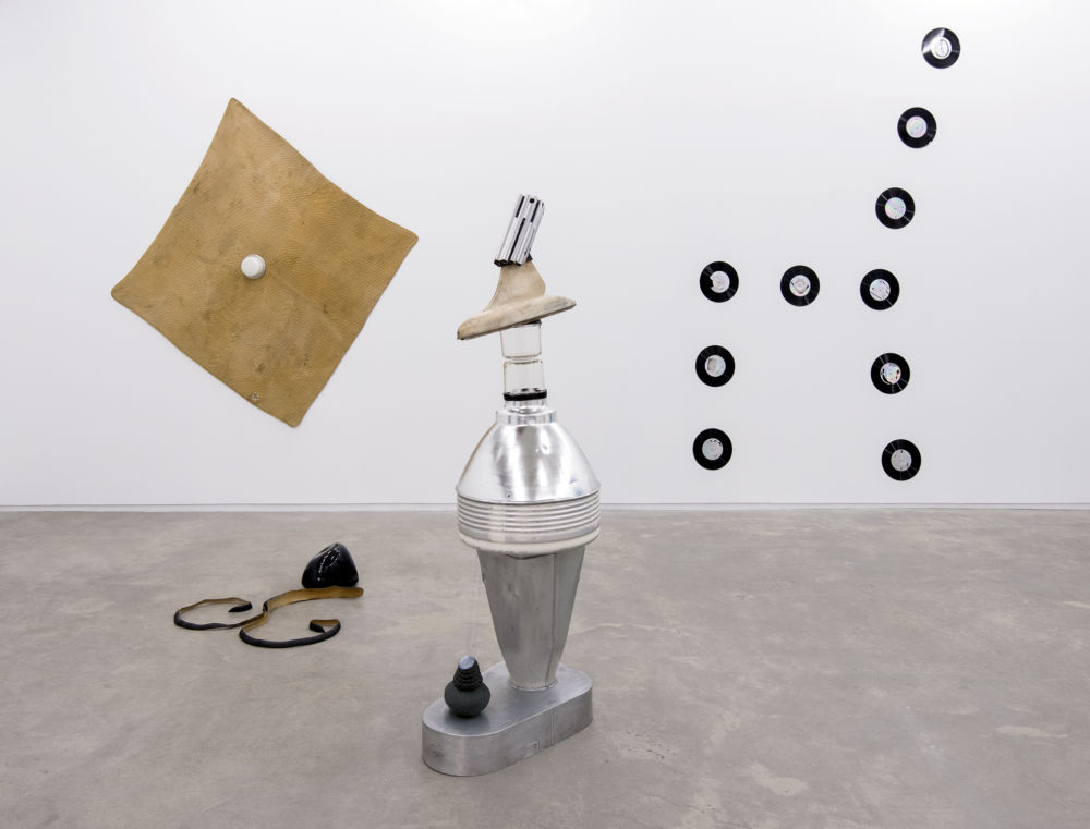 Jerry Pethick, Kolossus of Kindergarden, 1987–1989, spectra-foil on records, aluminium, blown glass, wood, rock, tires, cargo blanket, dimensions variable by 