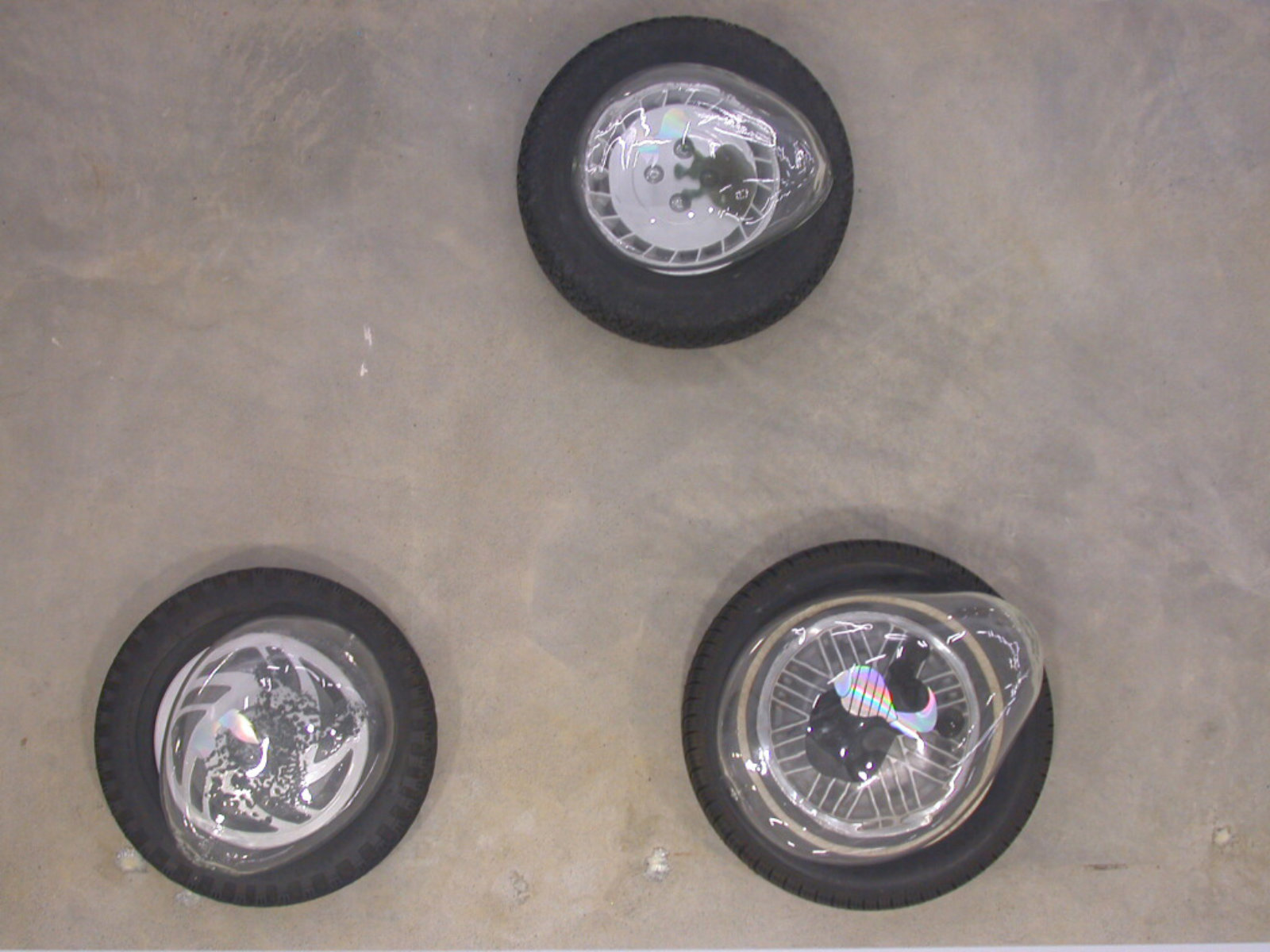Jerry Pethick, Aerial View, 2001–2002, tires, spectrafoil cut-outs, black silicone, blown glass, dimensions variable