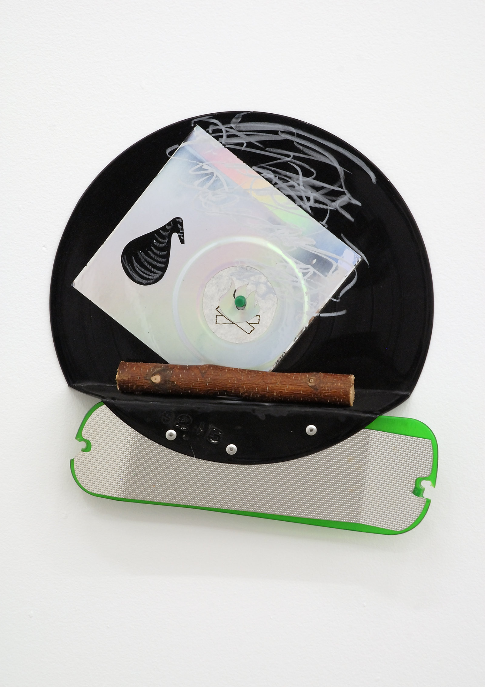Jerry Pethick, Black Retort Travelogue, 1991/1992, Phonograph record, crayon, spectrafoil, plastic fishing lure, piece of wooden branch, metal screws, 12 x 13 x 2 in. (30 x 32 x 5 cm)  