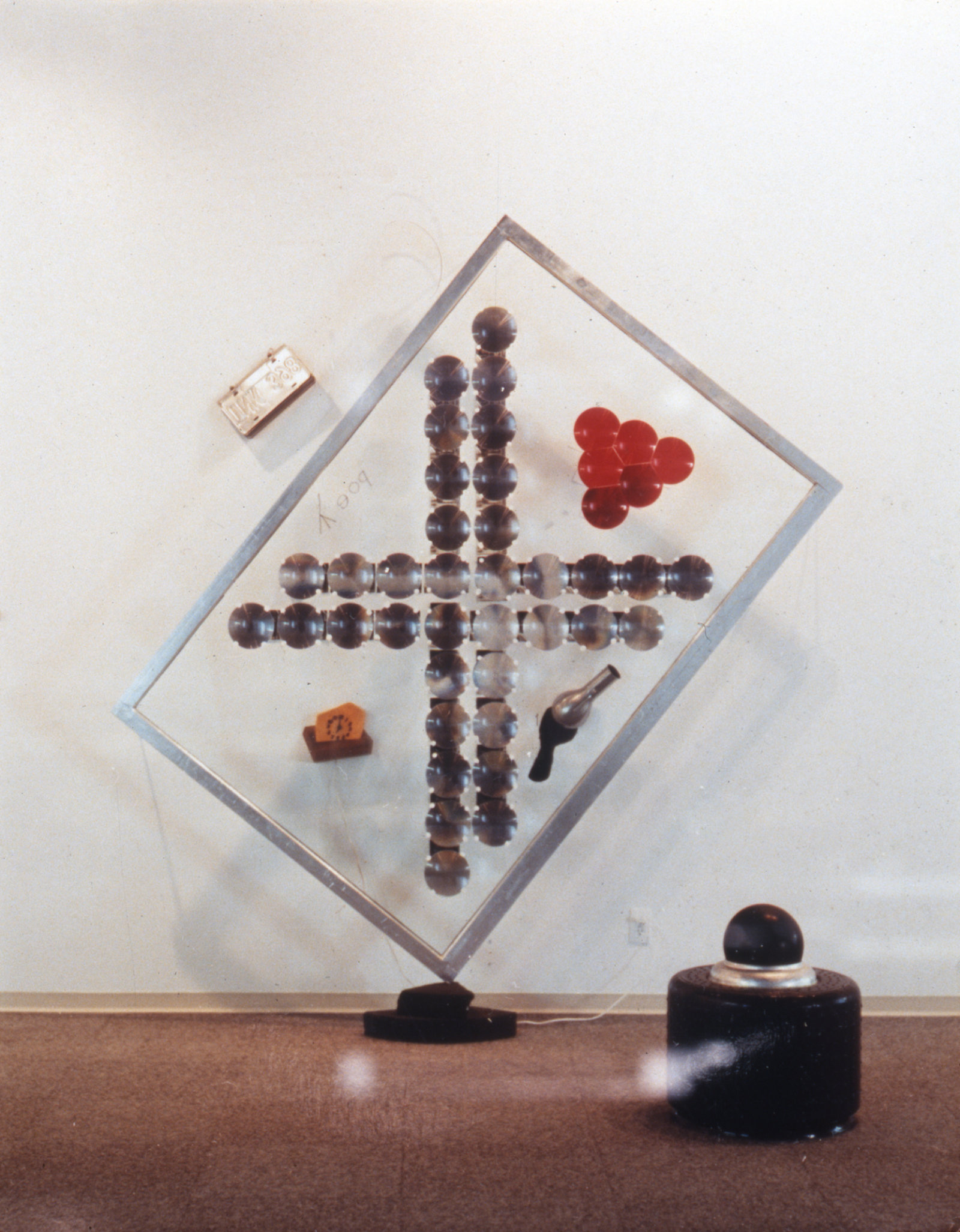 Jerry Pethick, Composite Portrait, 1990, wood, plastic fresnel lenses, red lens, license plates, plastic, stainless steel, flowers cubist plastic cheese, clock, carborundum grinding wheels, glass, 92 x 98 x 13 in. (233 x 249 x 33 cm)