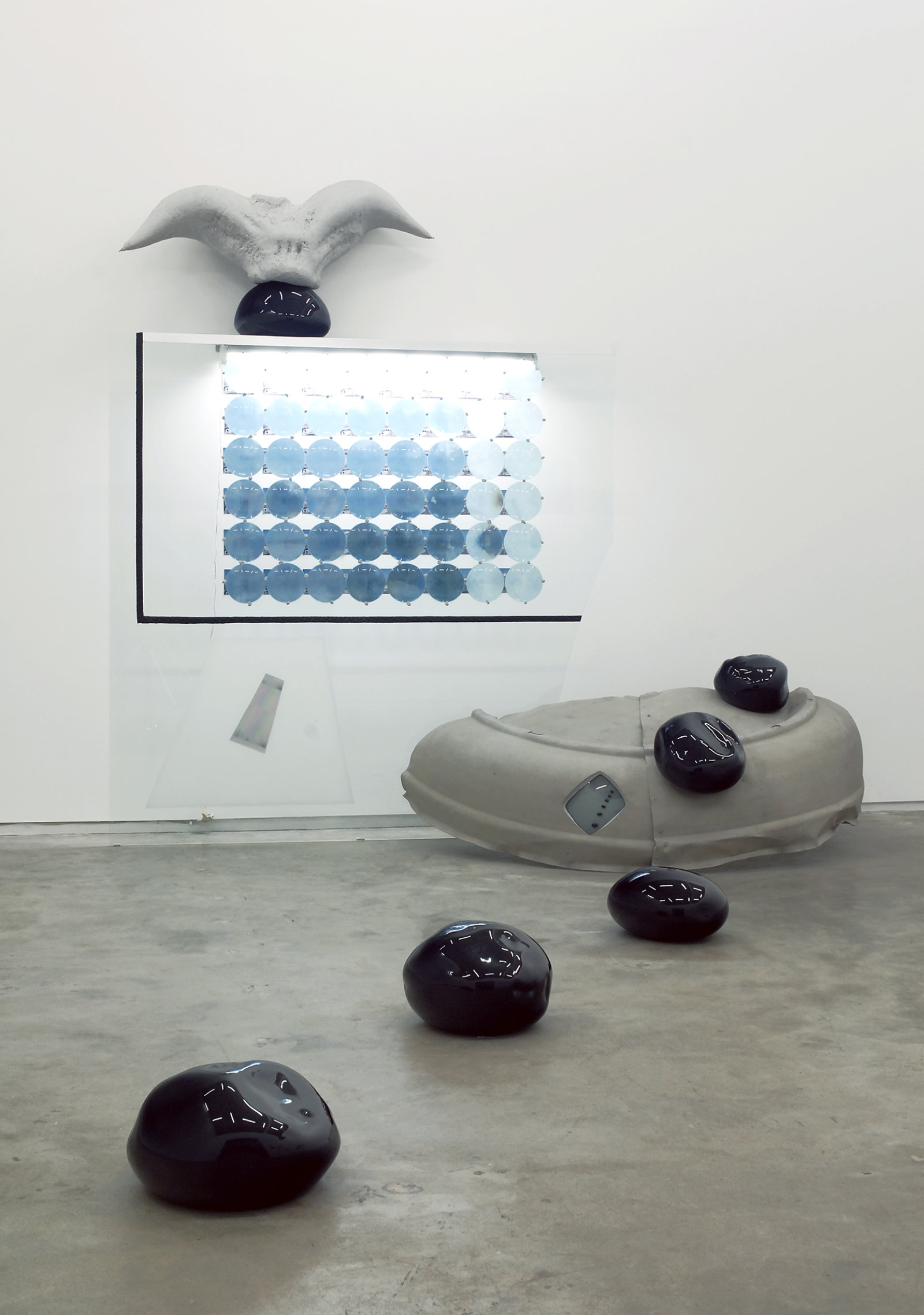 Jerry Pethick, Roof to Heaven Too, 1986–1988, blown glass, glass, rubber tire, TV tube, stones, aluminum, spectrafoil, 48 instamatic prints, 48 blue fresnel lenses, styrofoam, silicone, fluorescent light fixture, 169 x 111 x 75 in. (429 x 282 x 191 cm)
