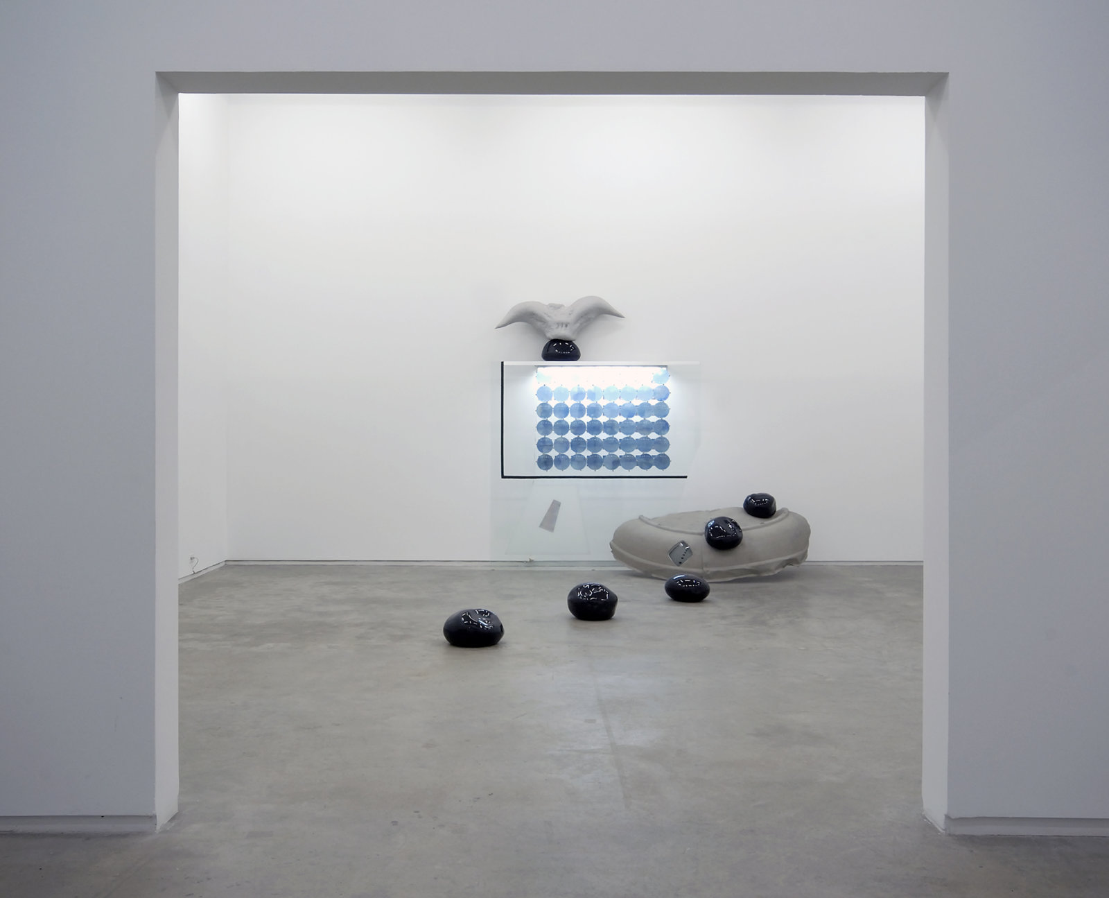 Jerry Pethick, Roof to Heaven Too, 1986–1988, blown glass, glass, rubber tire, TV tube, stones, aluminum, spectrafoil, 48 instamatic prints, 48 blue fresnel lenses, styrofoam, silicone, fluorescent light fixture, 169 x 111 x 75 in. (429 x 282 x 191 cm)