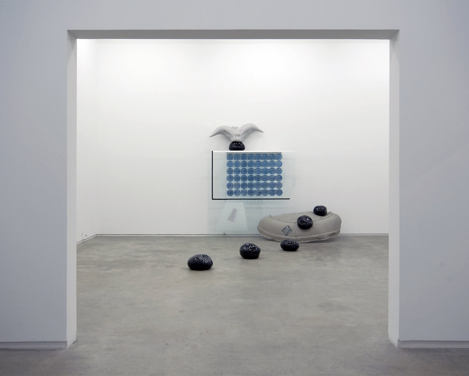 Jerry Pethick, Roof to Heaven Too, 1986–1988, blown glass, glass, rubber tire, TV tube, stones, aluminum, spectrafoil, 48 instamatic prints, 48 blue fresnel lenses, styrofoam, silicone, fluorescent light fixture, 169 x 111 x 75 in. (429 x 282 x 191 cm)