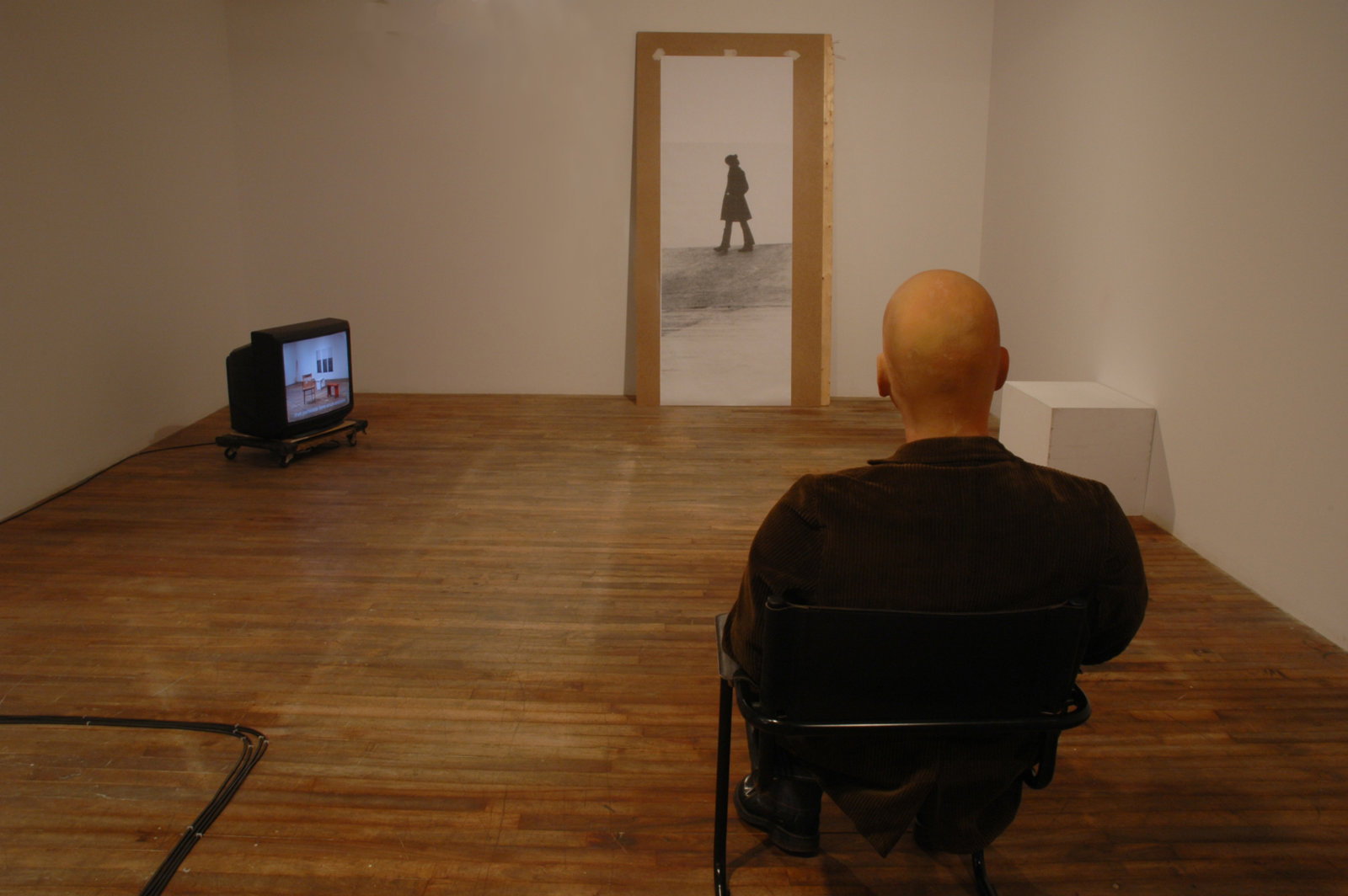 Judy Radul, Proposal for Ghost Pass Rehearsal Park, 2006, 9 TV monitors, 3 live cameras, audio and DVD playback, 3 distribution amplifiers, video mixer, prerecorded sound, photograph, hollywood stunt dummy, assorted furniture, 8 minutes, 55 seconds. Installation view, Oboro	Gallery,	Montreal,	QC, 2006