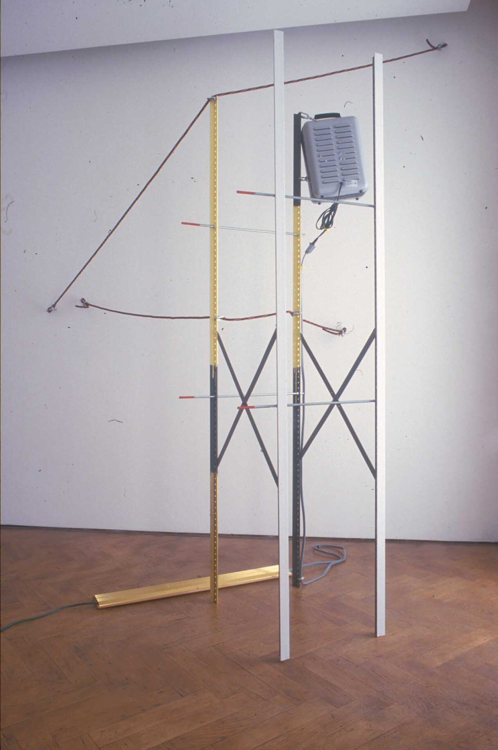 Jessica Stockholder, Coupling, 1998, metal shelving elements, threaded rod, carpet, fur, blankets, clothing, oil-based enamel paint, oil paint, acrylic paint, wheel barrow, light stand, extension cords, rope, hardware, brass and wooden threshold plates, space heater with fan, 166 x 149 x 111 in. (422 x 378 x 281 cm)