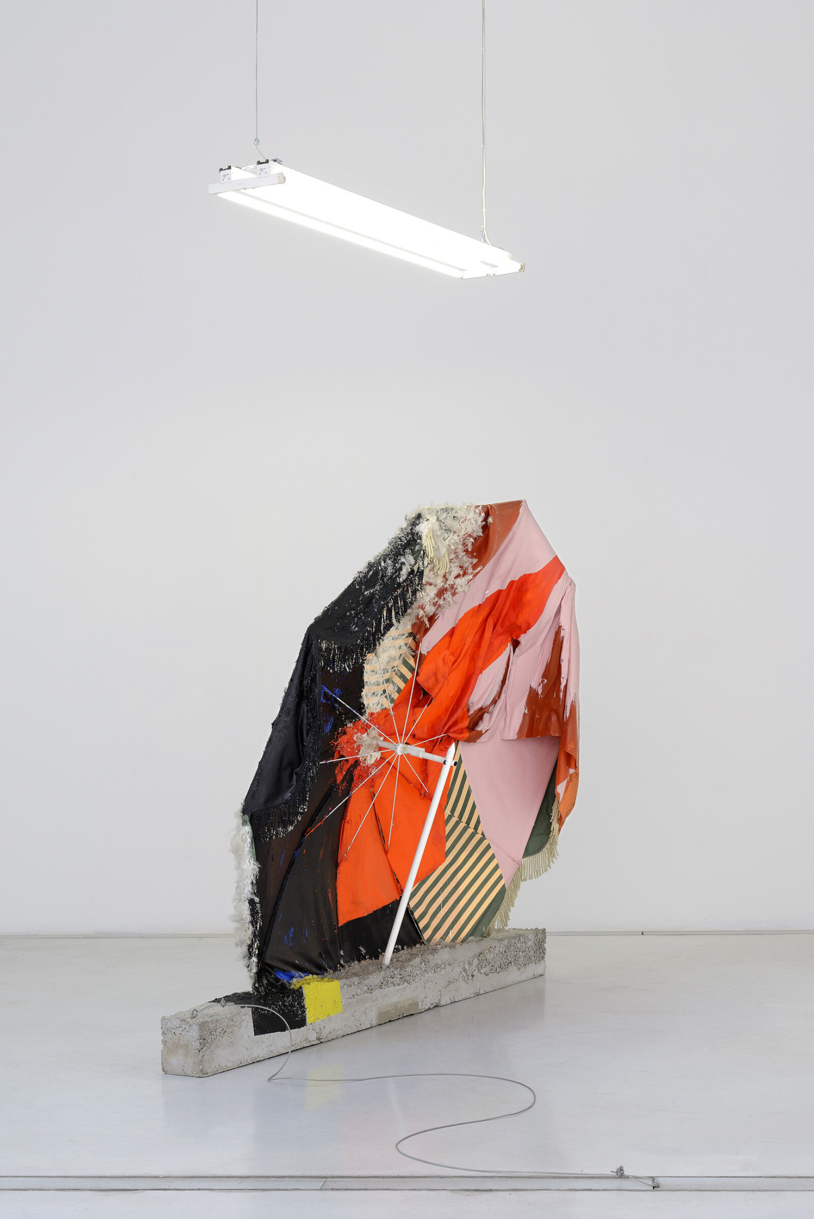 Jessica Stockholder, Edge of Hot House Glass, 1993, sun umbrella, acrylic paint, concrete, cable feathers, cloth, grow lights, cable, 75 x 91 x 28 in. (190 x 230 x 70 cm)