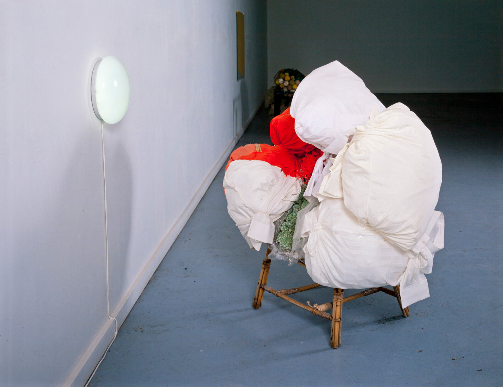 Jessica Stockholder, JS109, 1989, wicker chair, men’s shirts stuffed with foam wrapping material, oil paint, plaster, fluorescent light fixture