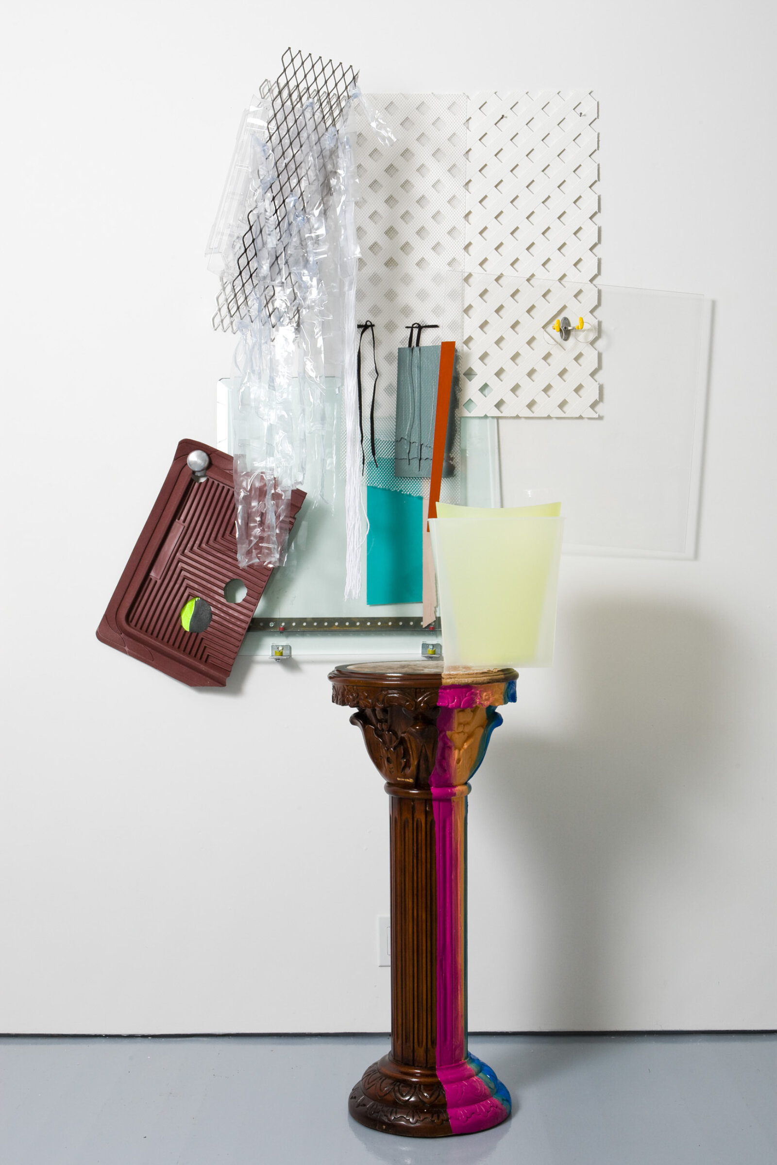 Jessica Stockholder, JS471, 2008, wooden pedestal made in China, rubber car mat, glass, plexiglas, metal mesh, plastic parts, hardware, plastic mesh fencing, plastic bins, doorknob, plastic shower curtain strips, oil and acrylic paint, 89 x 56 x 27 in. (226 x 142 x 69 cm)