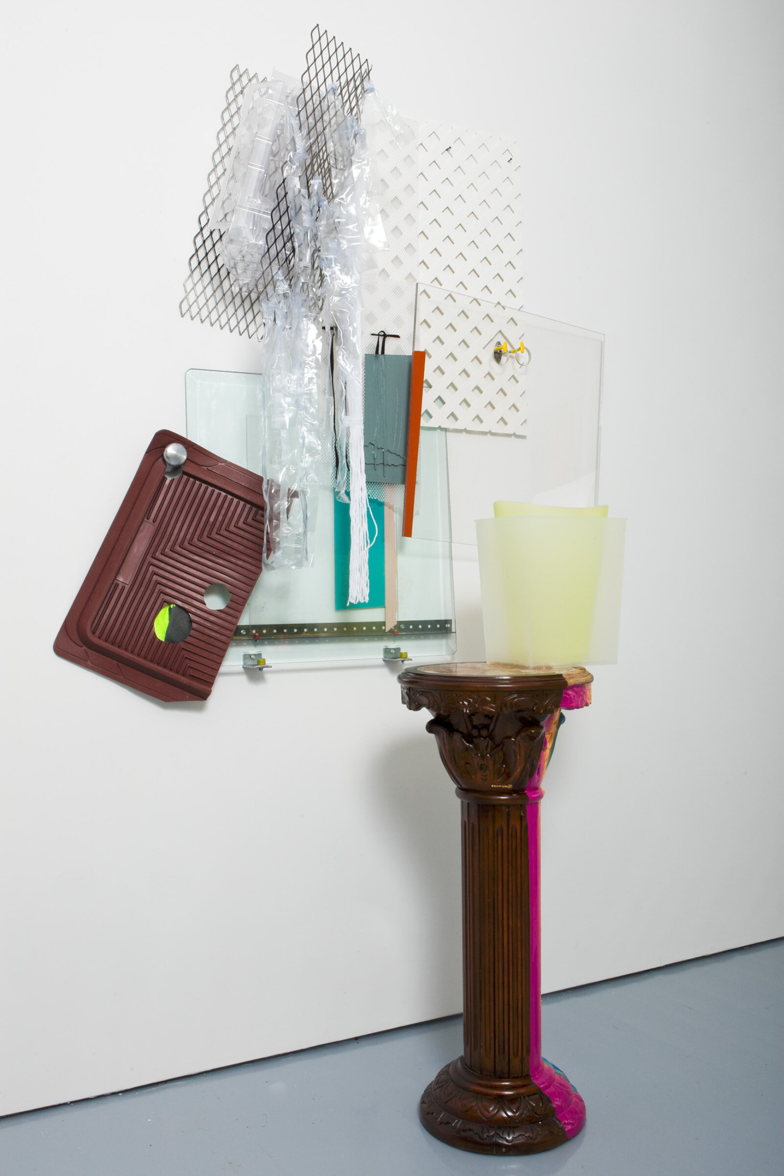 Jessica Stockholder, JS471, 2008, wooden pedestal made in China, rubber car mat, glass, plexiglas, metal mesh, plastic parts, hardware, plastic mesh fencing, plastic bins, doorknob, plastic shower curtain strips, oil and acrylic paint, 89 x 56 x 27 in. (226 x 142 x 69 cm)