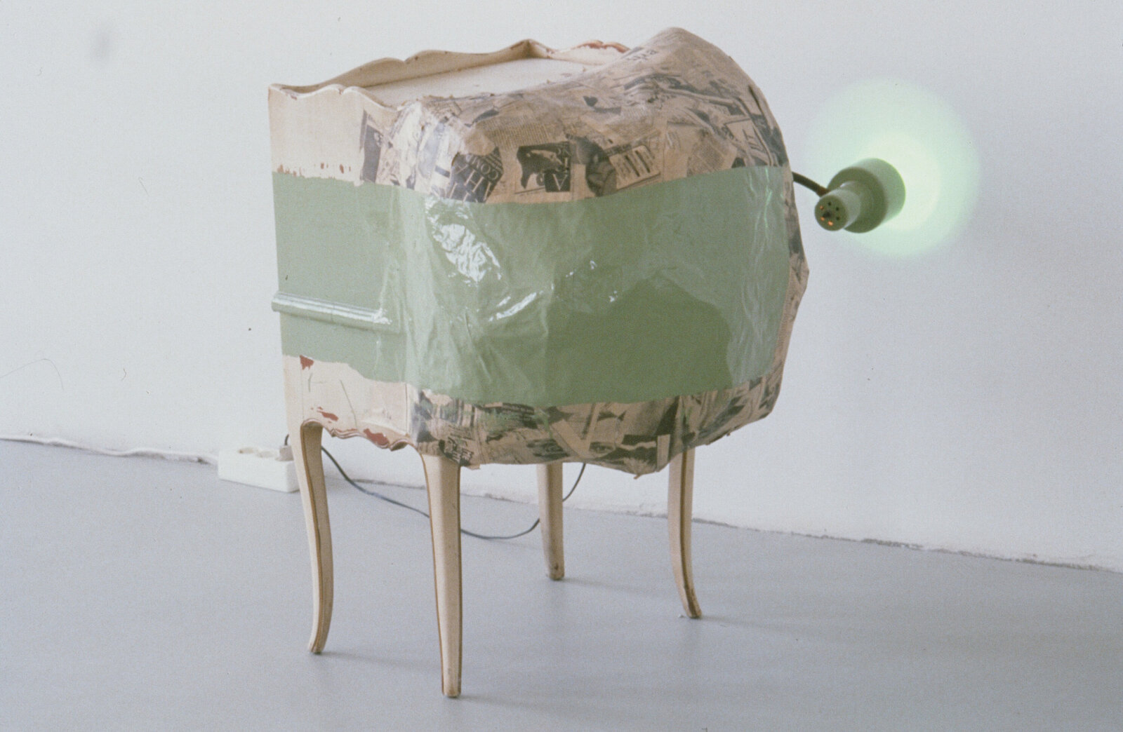 Jessica Stockholder, Kissing the Wall #1, 1988, furniture, enamel, incandescent light, newspaper with glue